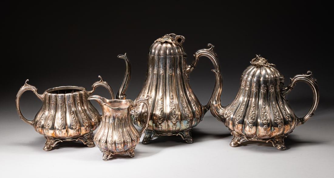Set old Silver Plated Tea Pot Sets: A set of old silver plated tea pot sets, including two tea pots in identical form, the body with multiple vertical grooves and carved with flower motif,, the curvy handles and spout both with flower d
