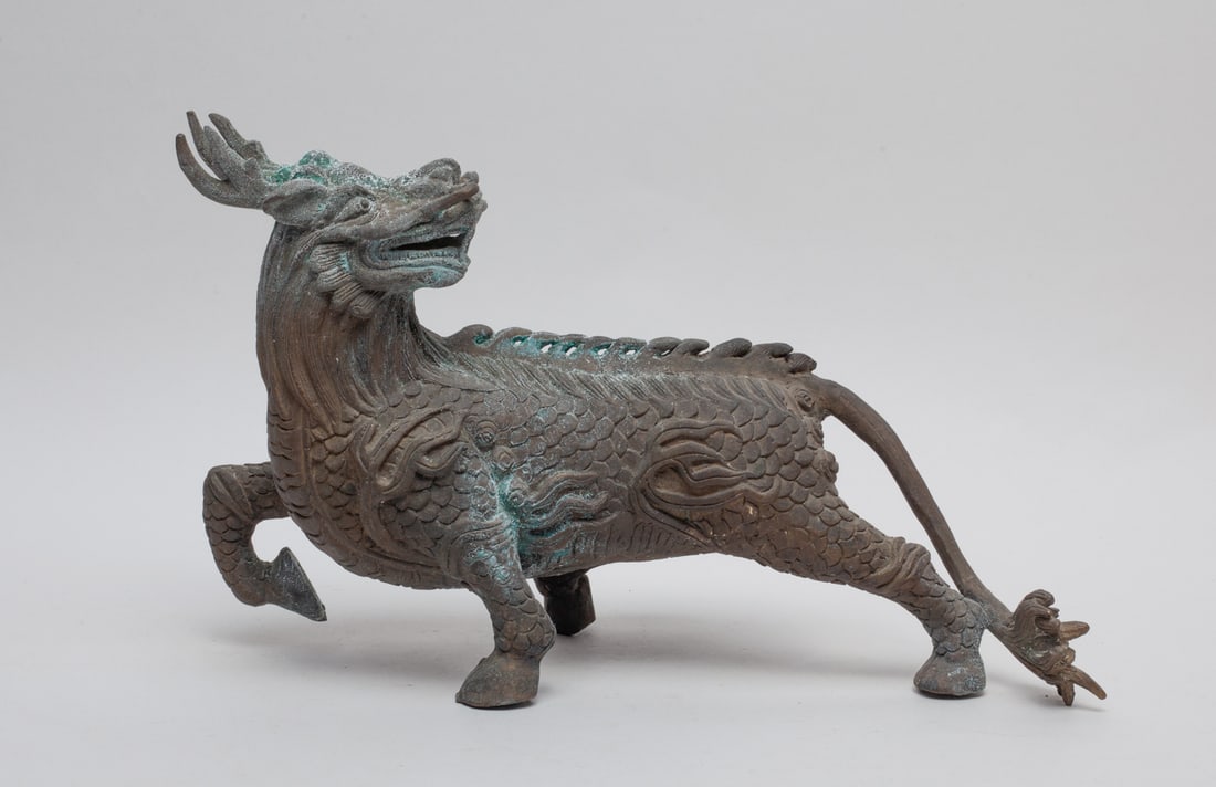 Chinese Bronze Sculpture of Chilin: One collectible bronze Chilin sculpture, in a walking stance, with one front leg raised up and the head looking back, partially oxidized. Approx. 11.0-7.0-3.5 inches.