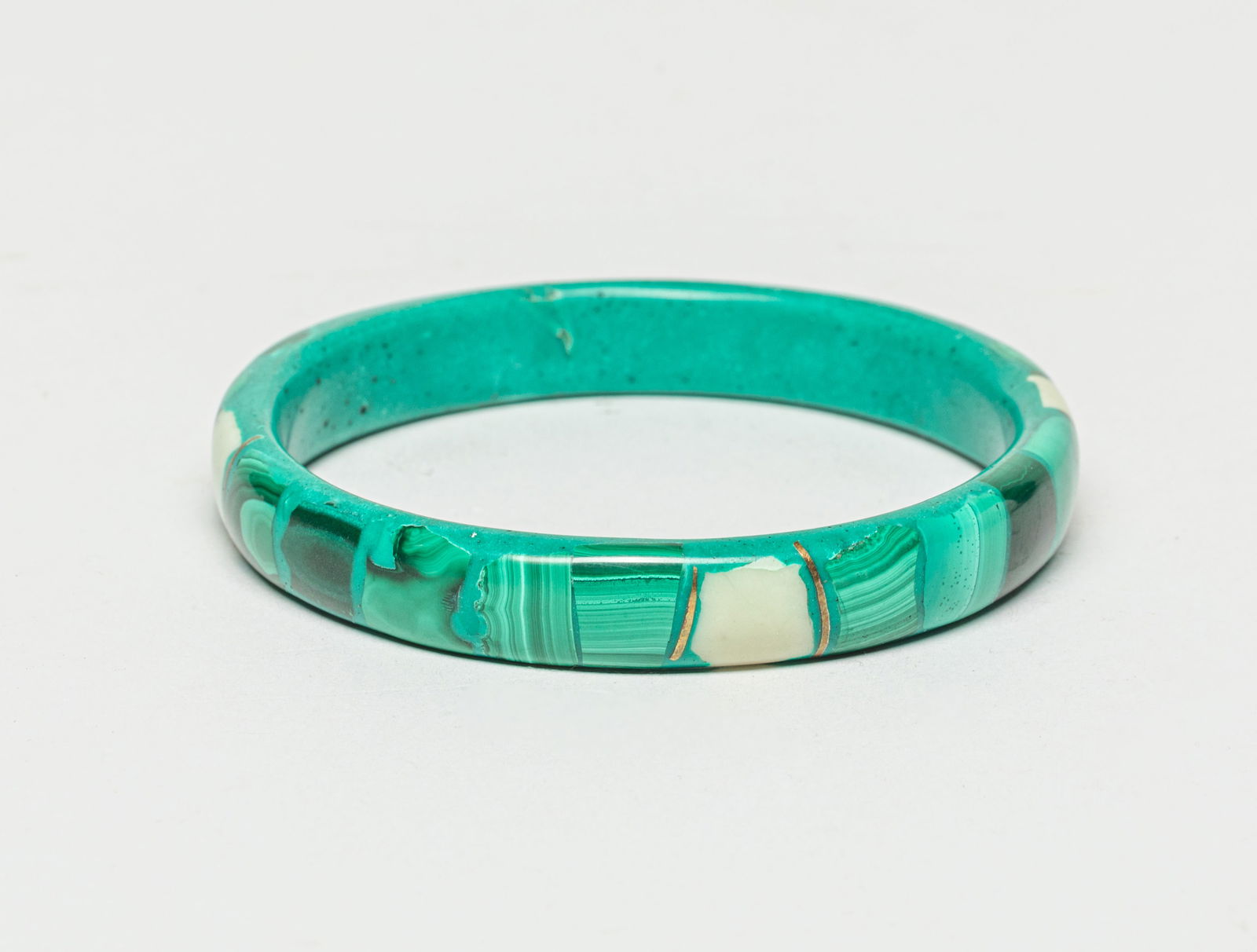 Designed Malachite Bangle: One designed malachite bangle. Approx. Outer Diameter: 2.9 inches, Inner Diameter: 2.4 inches.