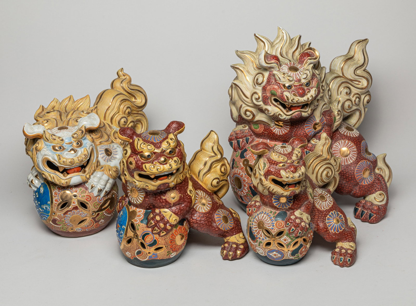 Set Japanese Porcelain Foo Dogs: A set of Japanese porcelain Foo dogs with stylized decorations and colored patterns, all in various poses. Approx. 13.0-10.0-14.5 inches (Largest).