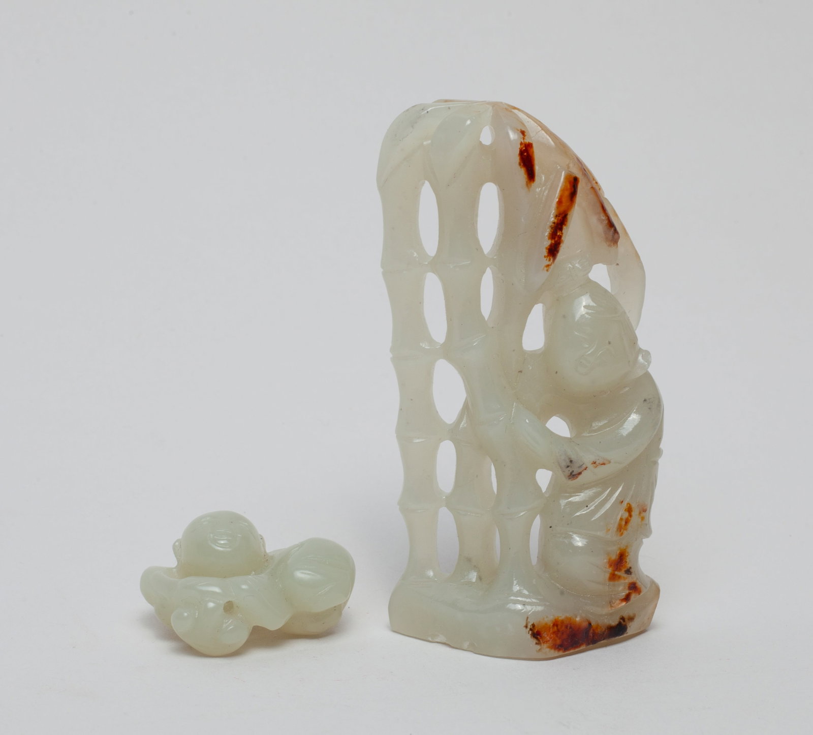 Two Chinese Jade Carvings: Including one carved with a figure beside a set of bamboo, and one carved with a figure holding a Linzhi. Approx. 1.7-0.8-3.1 inches (Largest).