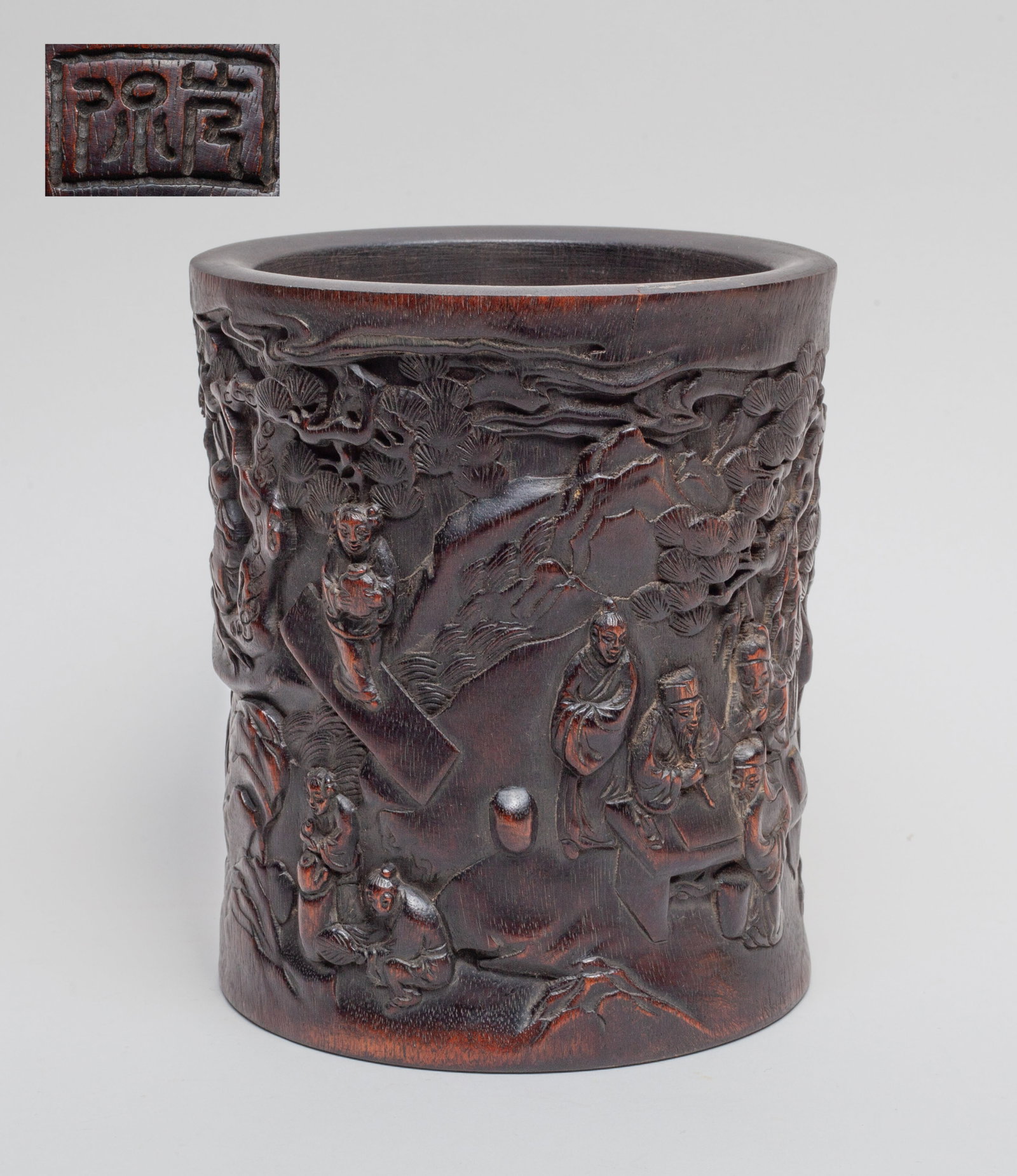 Chinese Bark of Agarwood Brush Pot: The exterior carved in high relief of multiple figures engaged in various activities, along with large trees, rocks, a seal mark, and cloud motif at the rim. Approx. 5.5-6.5 inches.