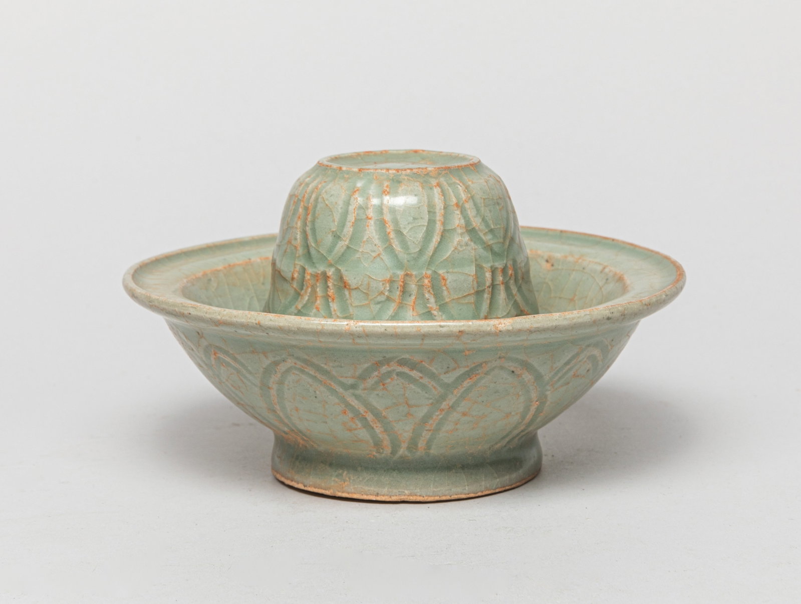 Korean Porcelain Lotus Stand: Carved with overlapping lotus petals, covered overall in mottled soft-celadon glaze suffused with a matrix of crackles. Approx. 5.9*3.3 inch.