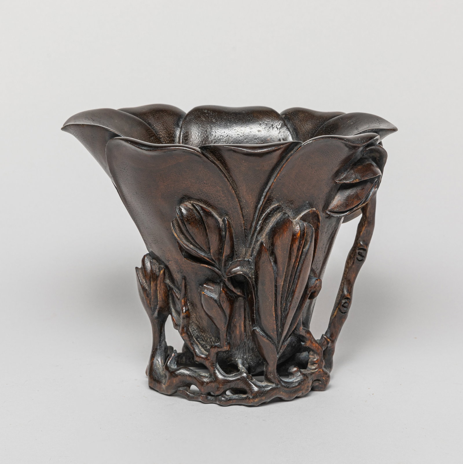 Chinese Bark of Agarwood Cup: One bark of agarwood cup, the exterior carved in high relief with flowers and leafy stem as handle. Approx. 196 g, 6.7-5.7 inches