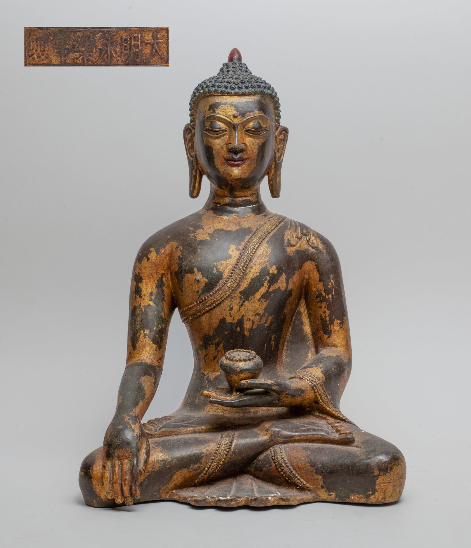 Large Chinese Painted Bronze Buddha: The Buddha seated in dhyanasana, the left hand holding an elm bowl and the right hand in Bhumisparsa mudra, with a six-character mark at the back. Approx. 11.0-7.0-15.5 inches.