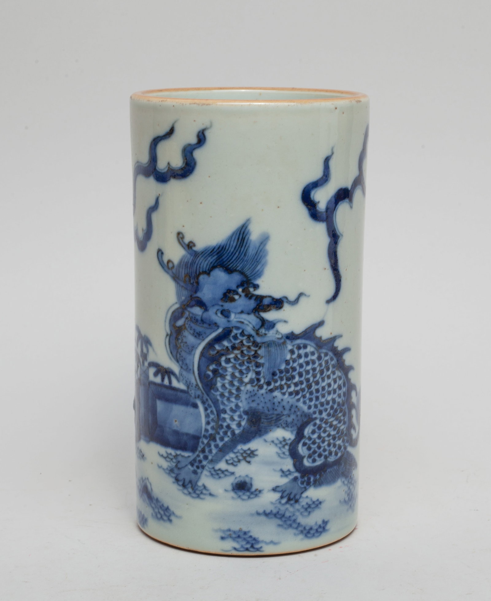 Chinese Blue & White Porcelain Brush Pot: The cylindrical brush pot painted with a sitting qilin in a garden setting. Approx. 3.7-7.0 inches.