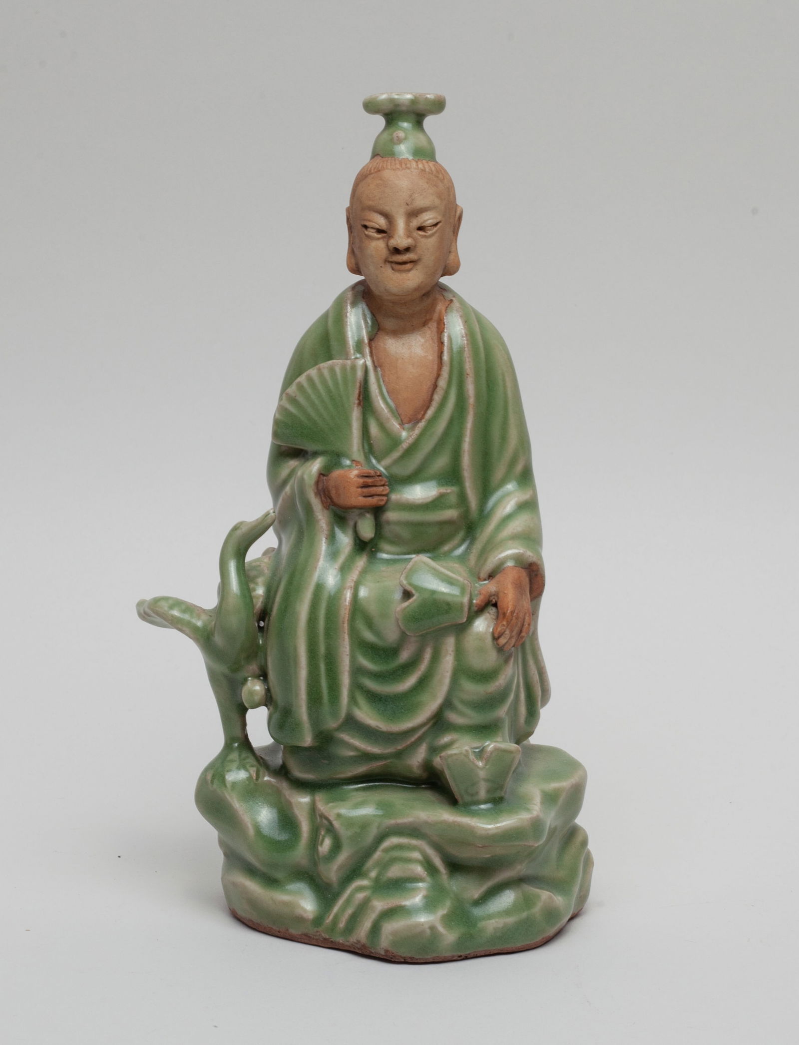 Chinese Longquan Porcelain Figure: The figure seated on rock with a bird standing aside, the left hand resting on the knee and right hand holding a fan, covered in celadon glaze save for the unglazed head, chest and hands. Approx. 8.3*