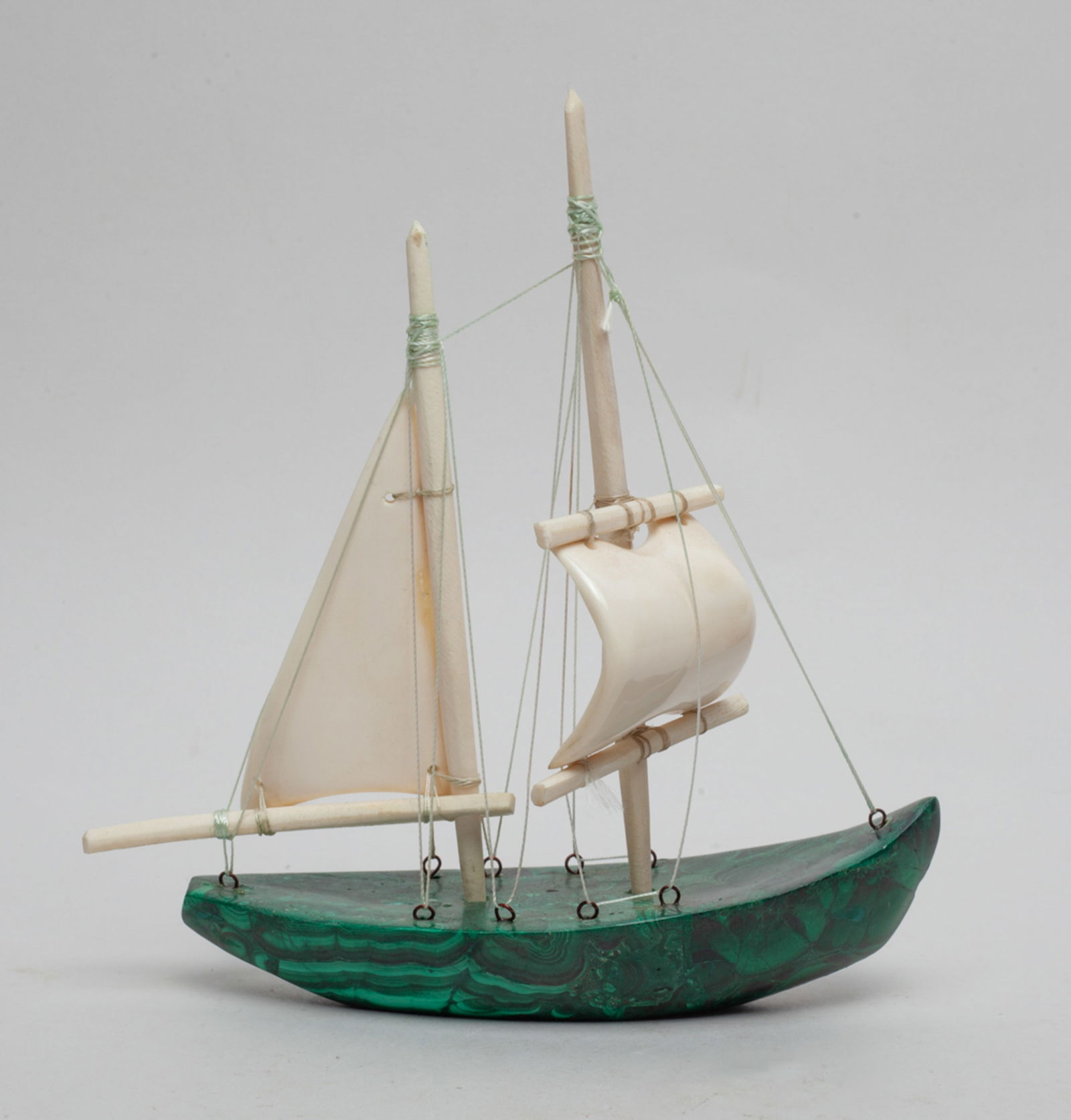 France Malachite & Bone Boat: One collectible boat decor, crafted with a France malachite boat body, and two born-made boat sails one in rectangular and one in bent square shape, two boat master stuck into the boat tired with stri
