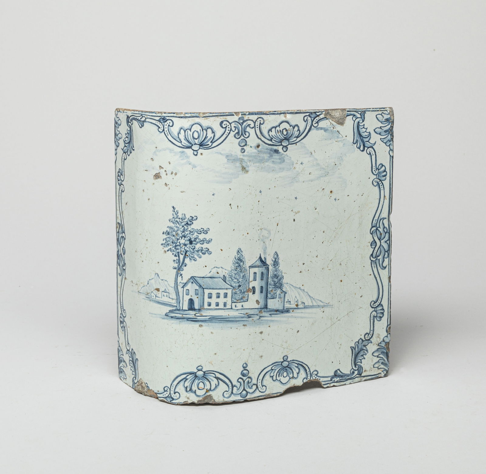 Lg Antique Dutch Porcelain Tile: The curvy surface painted with blue-toned buildings at a landscape setting. Approx. 9.0*9.0*4.0 inches.