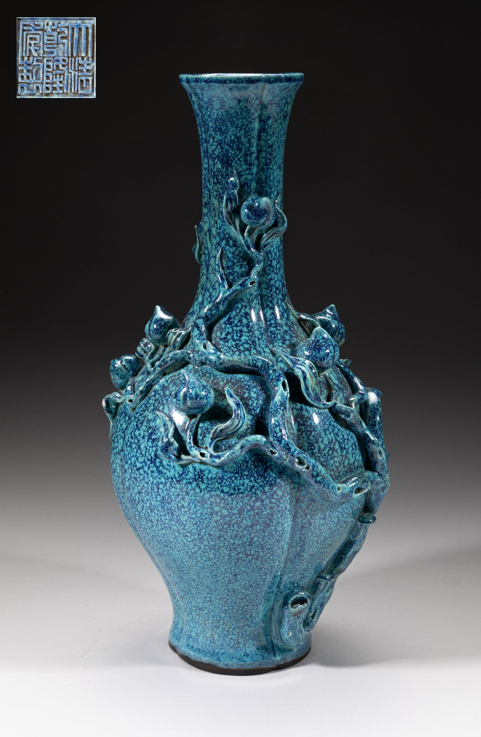 Chinese Export Porcelain Peach Vase: Of quatrelobed form, the ovoid body rising from a splayed foot to a slender neck and a flared rim, carved in high relief with fruiting peach tree branch, covered overall in turquoise glaze suffused wi