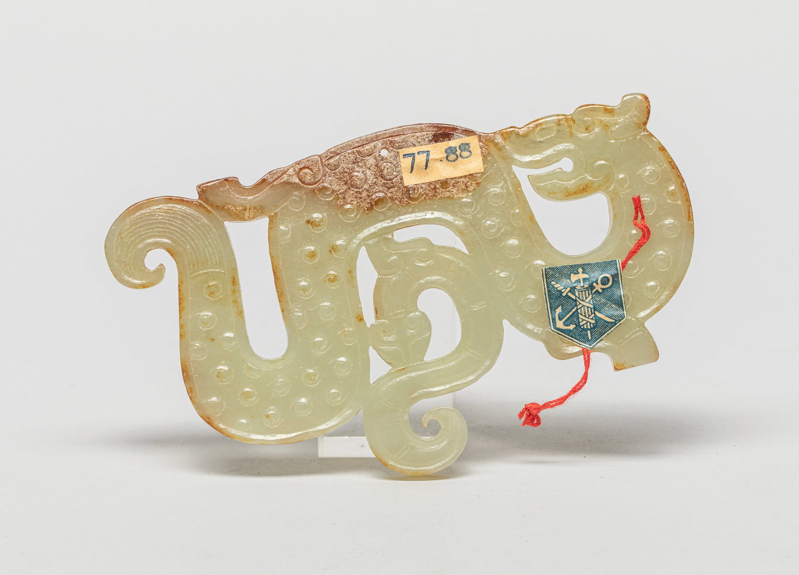 Chinese Russet Jade Carved Dragon: The dragon turning back in an 'S' shape facing its forked tail, the beast sinuous underneath the dragon body, decorated with raised spiral bosses within line borders on both sides, the pale celadon st
