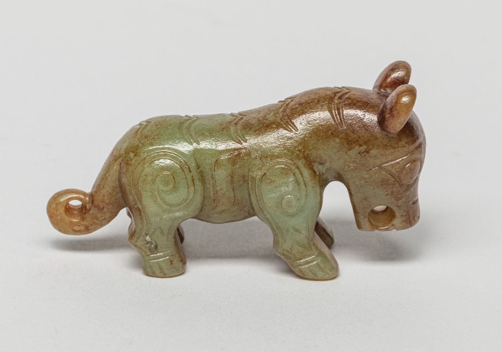 Chinese Russet Jade Beast: The russet jade beast carved standing foursquare, the head looking downwards, drilled at the mouth for suspension. Approx. 3*1.5*0.9 inch.