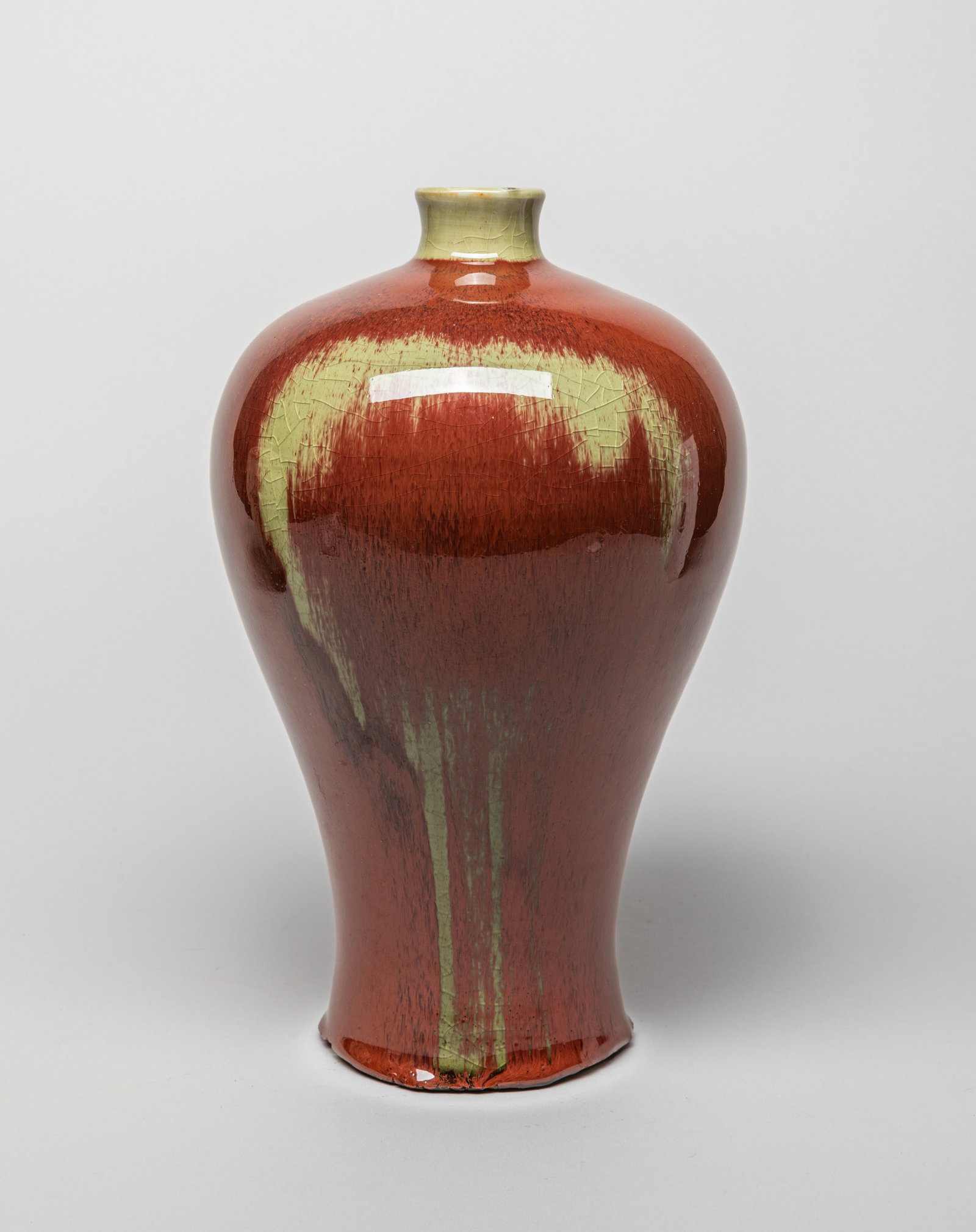 Chinese Flambe Glazed Porcelain Vase: Of baluster form with a short neck, the body covered in streaked red glaze with mushroom color splashes, the neck glazed in mushroom color, the bottom unglazed. Approx. 11.5*6.7 inch.