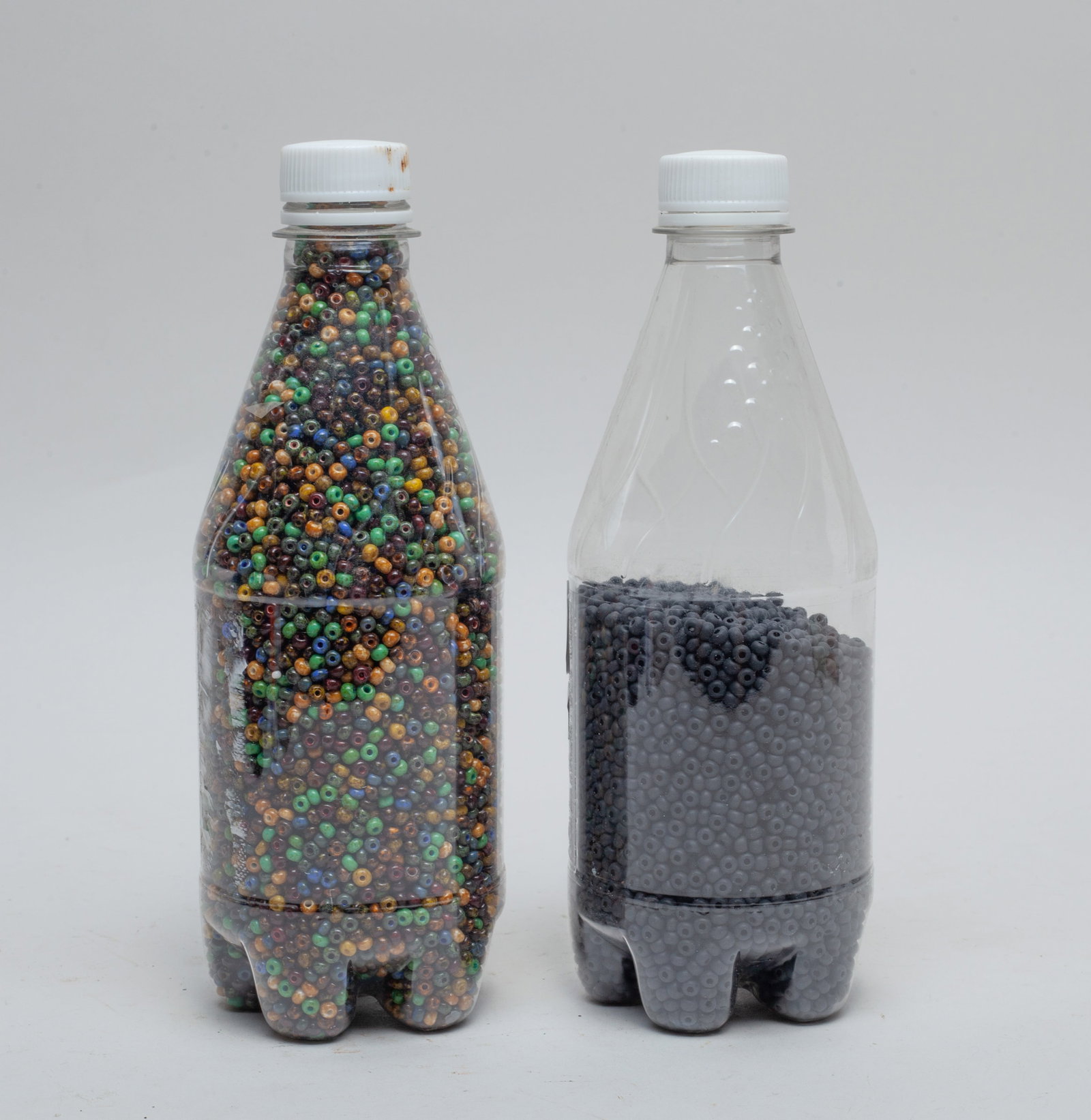 Two Bottles of Old Seed Beads: Two bottles of colored seed beads and black seed beads. Size varies.
