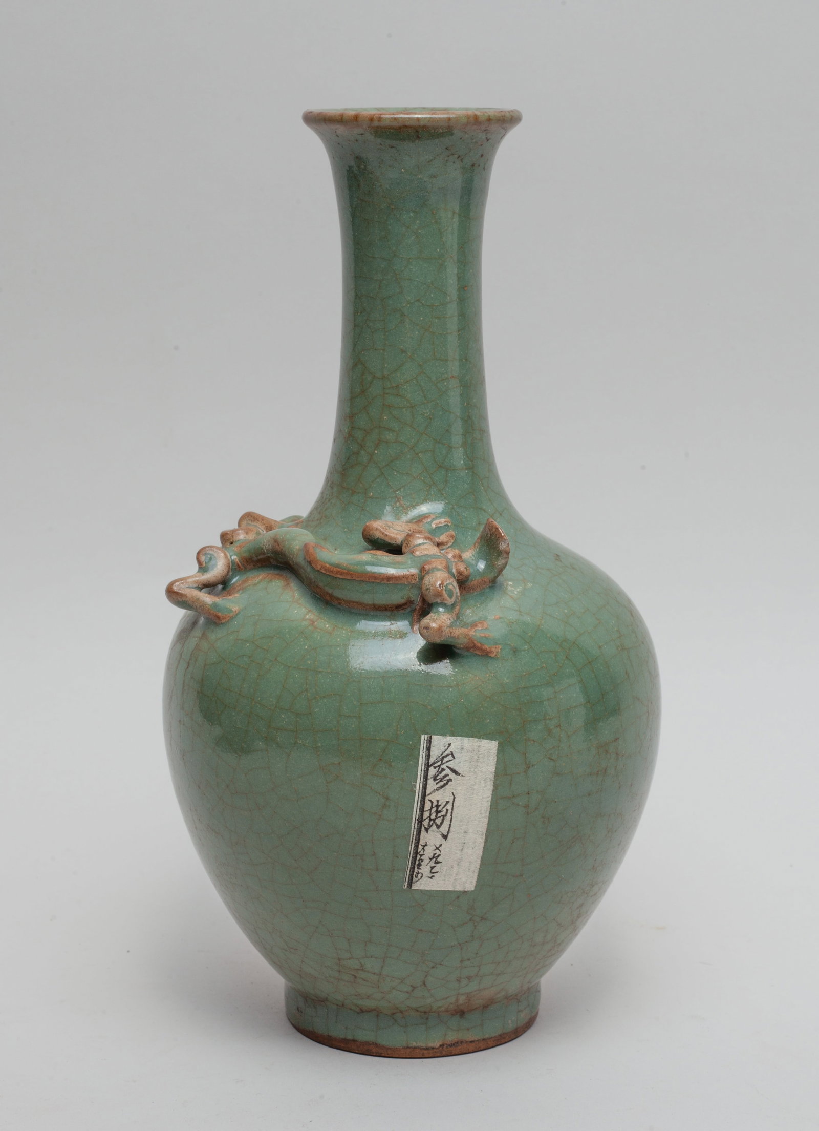 Chinese Longquan Porcelain Dragon Vase: The ovoid body rising from a short foot to a tall slender neck and a flared rim, carved in high relief with a sinuous chilong, covered overall in crackled celadon glaze. Approx. 9.6*5.1 inch.