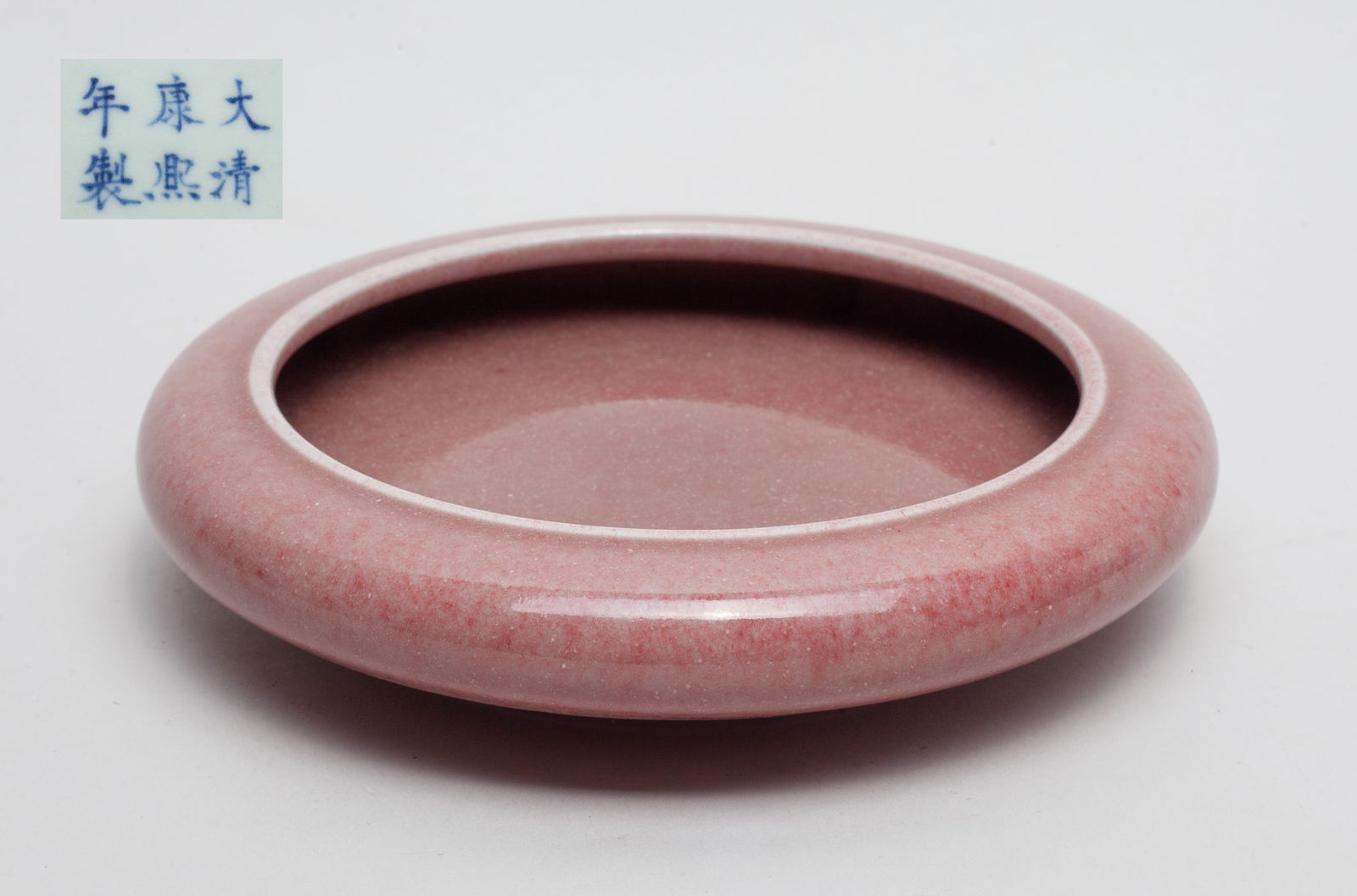Chinese Porcelain Brush Washer: Of shallow circular section, covered inside and out in soft copper-red glaze, the bottom marked with six characters on white ground. Approx. 6inch D.