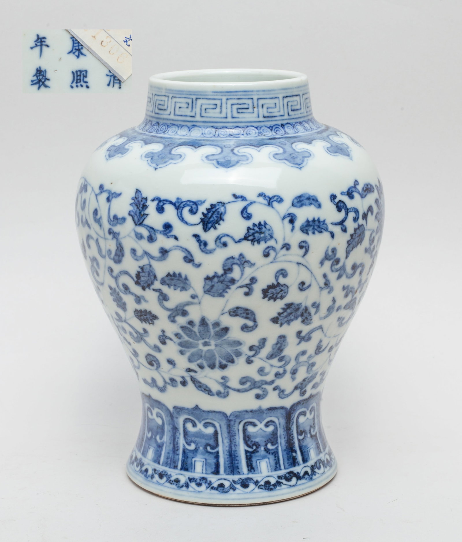 Chinese Blue & White Porcelain Vase: Of waisted ovoid form with a short cylindrical neck, the exterior painted with meandering lotus sprays between bands of ruyi heads and upright petals, the bottom marked with six characters. Approx. 4.