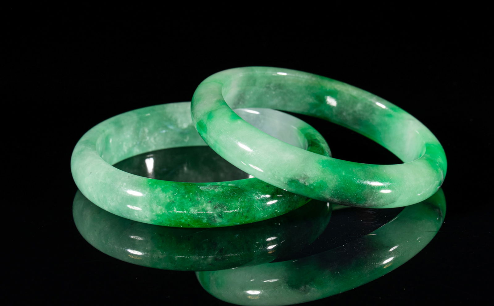 Two Chinese Export Bangles: Two collectible Chinese jade/colored stone bangles. Approx. Outer diameter 2.9 inches, Inner diameter 2.3 inches (Each).