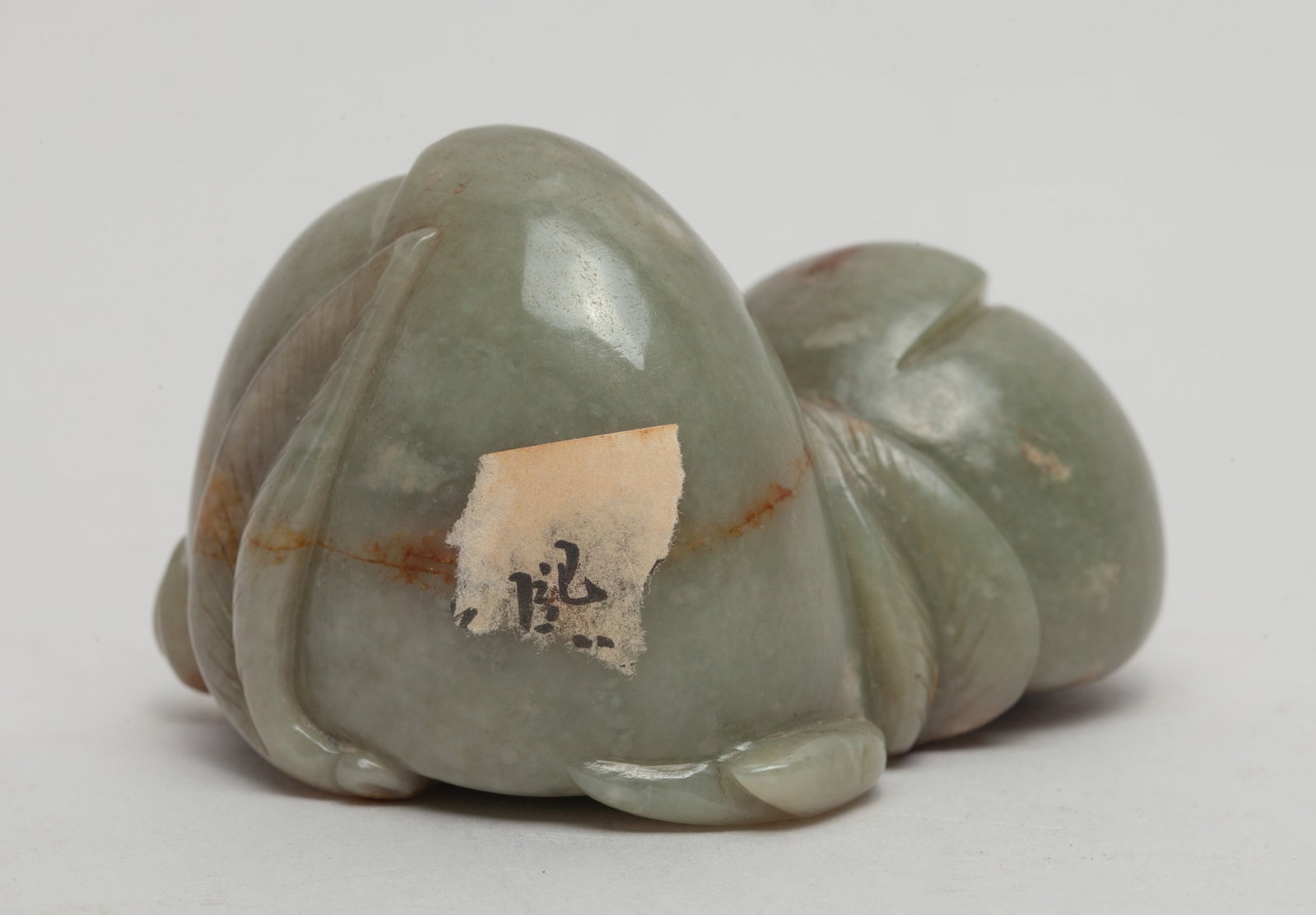 Chinese Jade Carved Sculpture of Peach: Carved in form of two peaches issuing from a leafy stem, the stone of celadon color with russet inclusions. Approx. 2.75*2.3*1.9 inch.