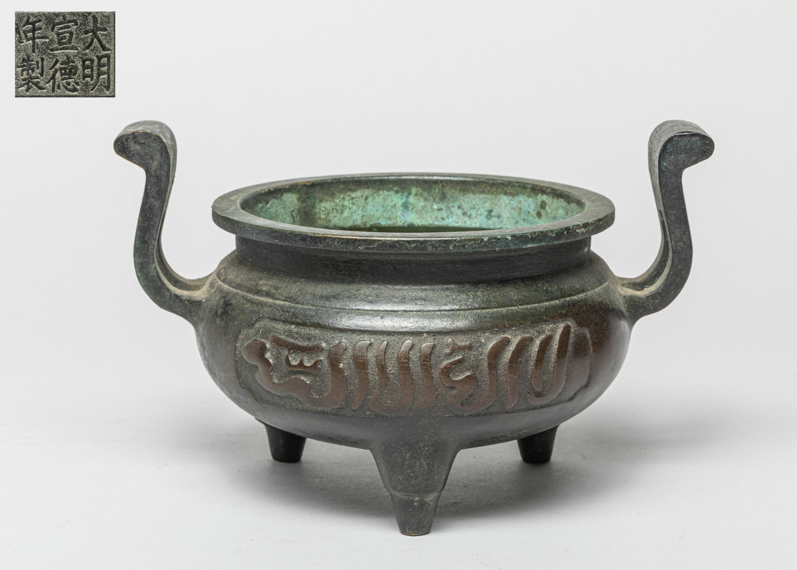 Chinese Temple Used Bronze Censer: The compressed globular body raised on three cabriole legs and features two curvy U-shaped handles, two panels of Arabic inscriptions molded on the opposing sides on the body, and the bottom bearing a