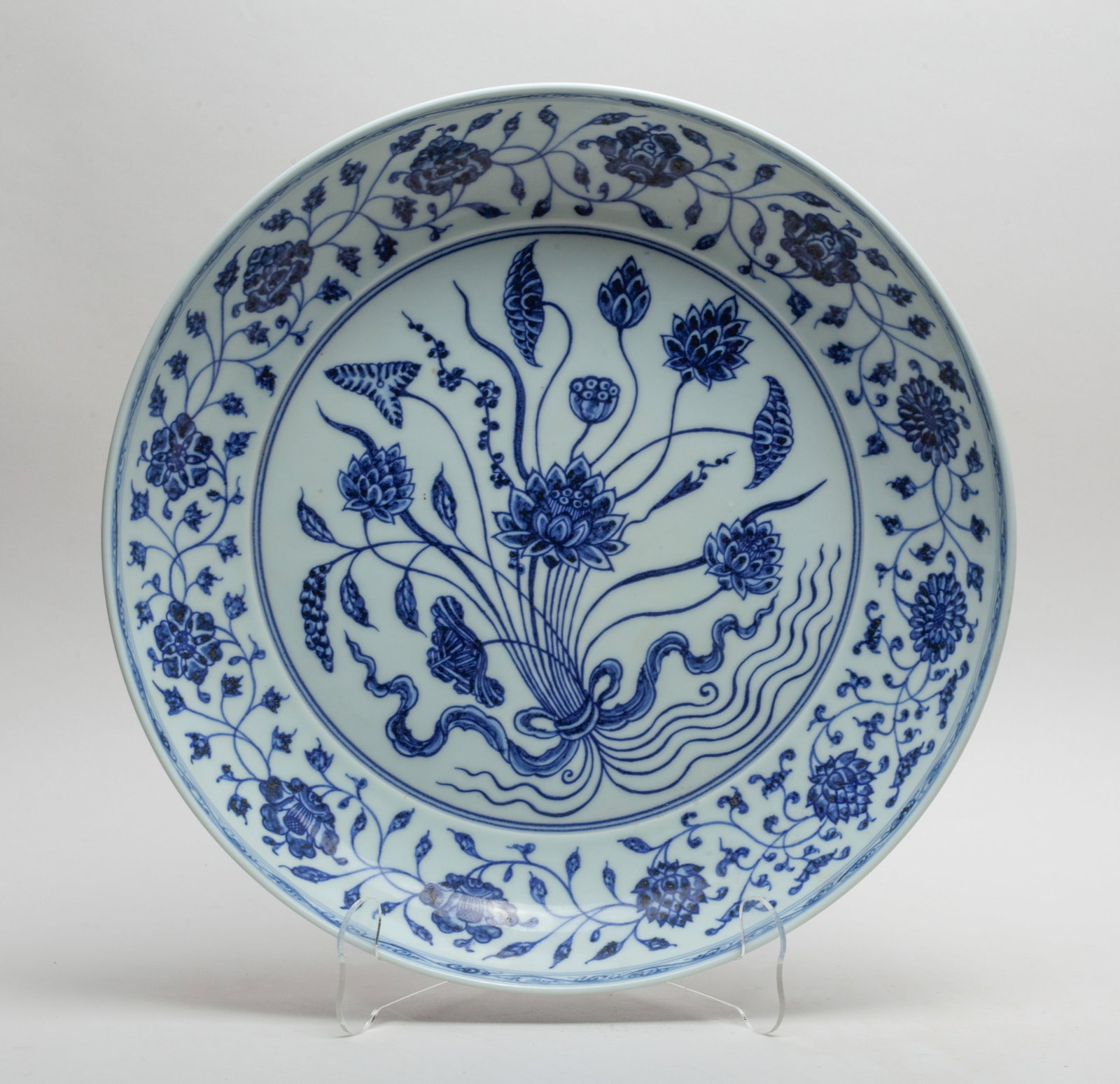 Chinese Export Porcelain Charger: Elegantly painted to the interior centre and exterior with lotus blooms borne on undulating leafy stems, the interior rim with similar patterns, the glaze stop at the base. Approx. 13.2*2.6 inch