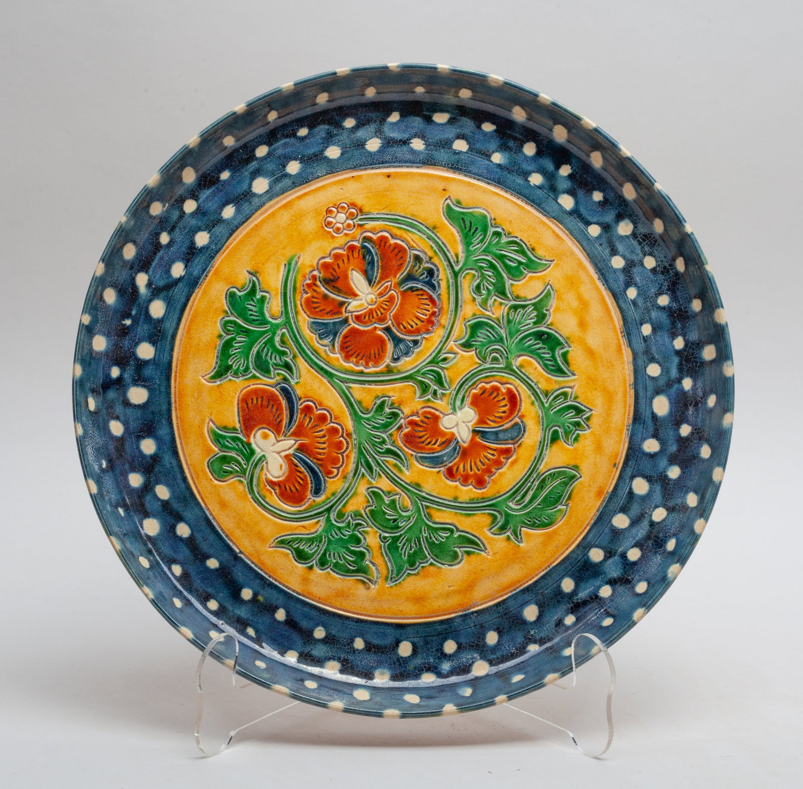 Chinese Sancai Stoneware Charger: The plate interior center carved with stylized flower, applied in blue, green and brown glaze. Approx. 11*1.1 inch