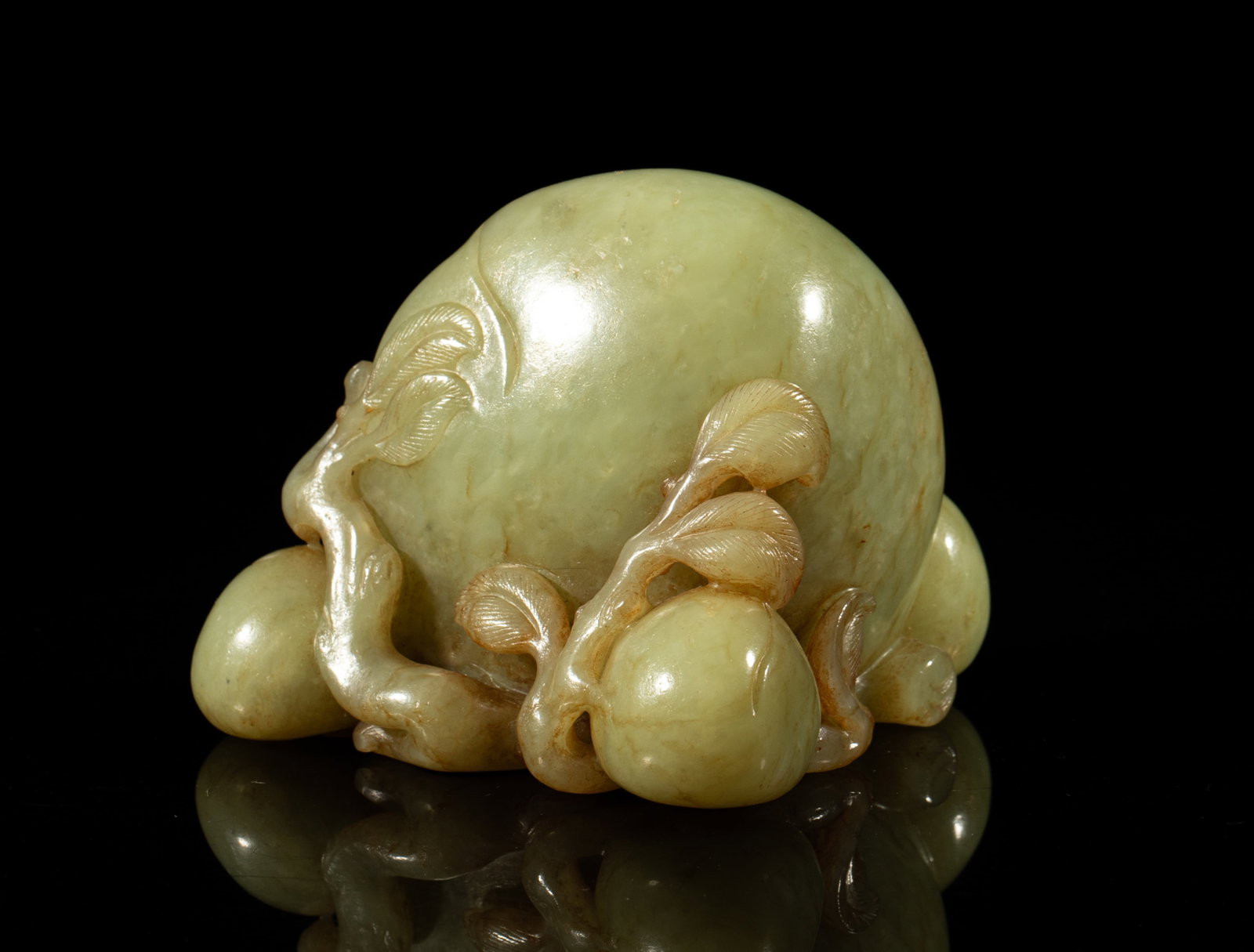 Chinese Yellow Jade Sculpture of Peach: The pebble deftly carved as a large ripe peach issuing from gnarled branches issuing further curling leaves and smaller peaches forming the base, the yellow jade with russet streaks. Approx. 3.4*3.2*2