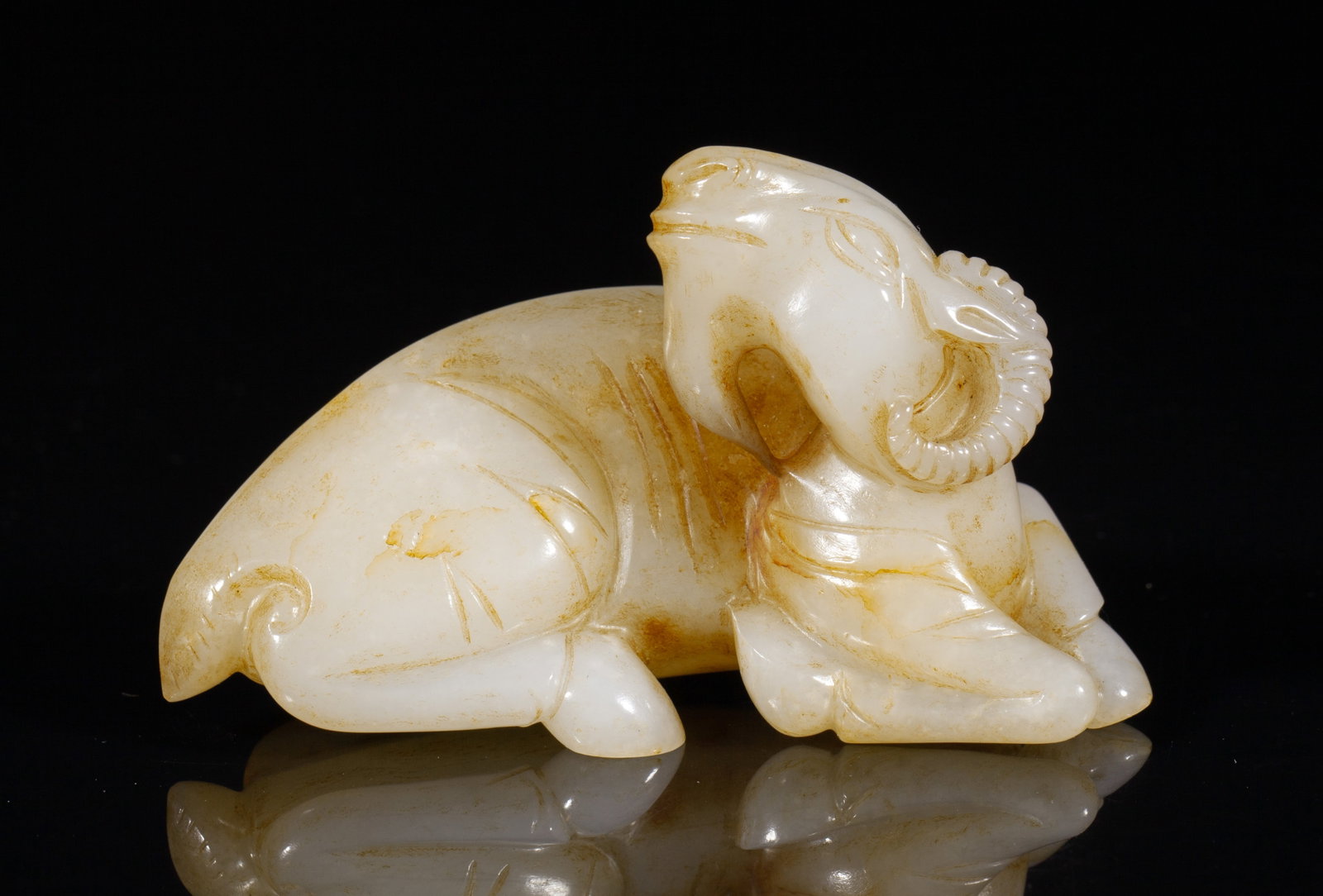 Chinese Russet Cream Jade Ram: Deftly carved russet jade ram, the head turned to the back, all with hoofed legs tucked under its body. Approx. 3.4*2.1*1.5 inch.