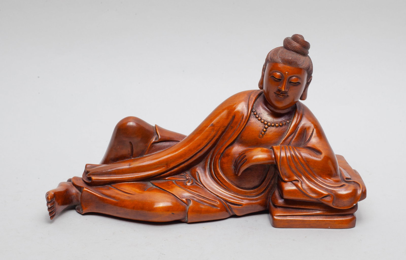 Chinese Box Wood Sculpture of Kuanyin: The boxwood Kuanyin carved lying on his side with left arm resting on a stand, wearing a long flowing robe. Approx. 8.7*5*3 inch.