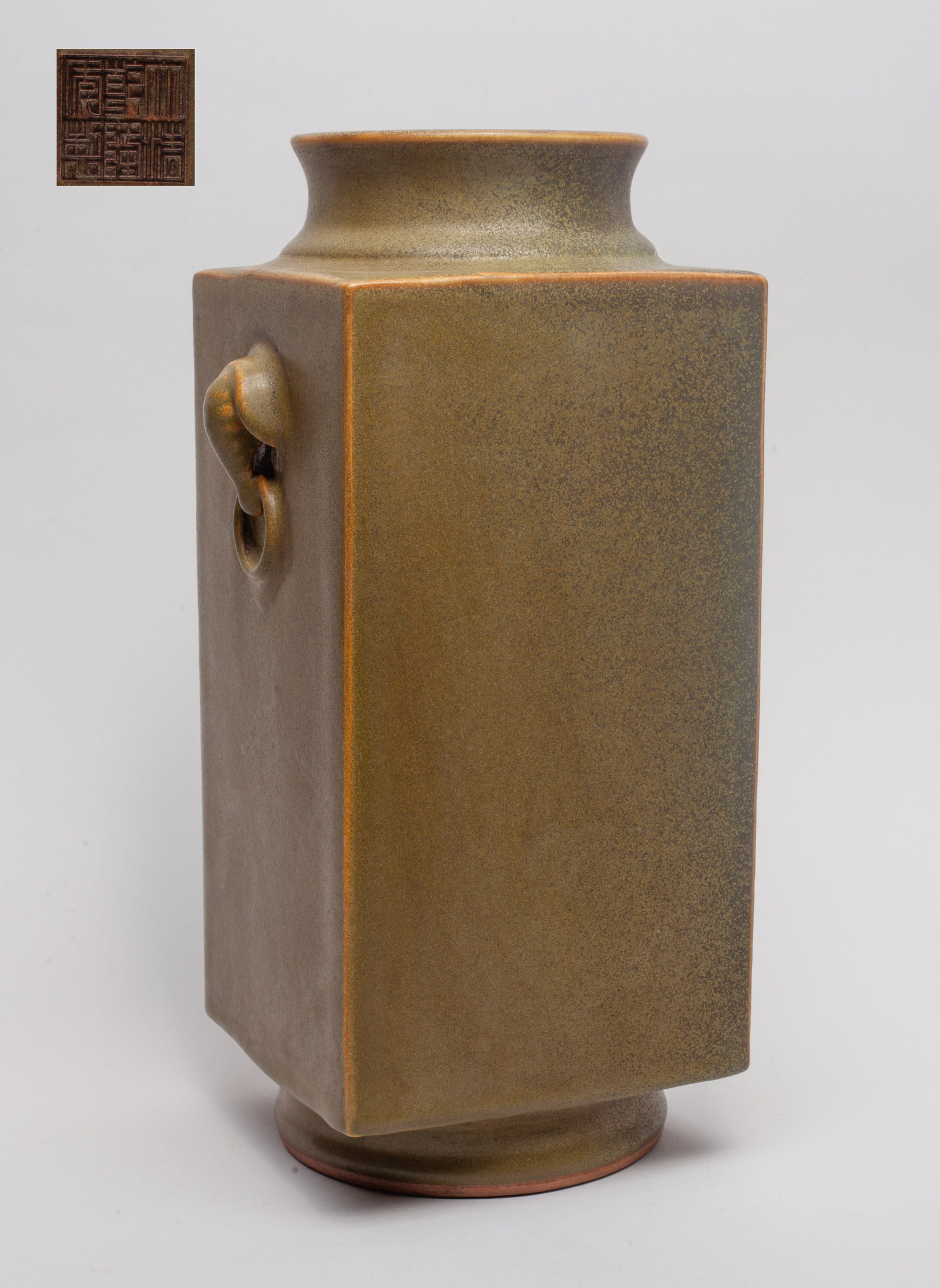 Chinese Tea Dust Glazed Porcelain Vase: Of tall square section with circular foot and mouth, flanked by faux-ring elephant head handles, overall covered in tea dust glaze, the bottom carved with a seal mark. Approx. 12.1*5*5 inch.