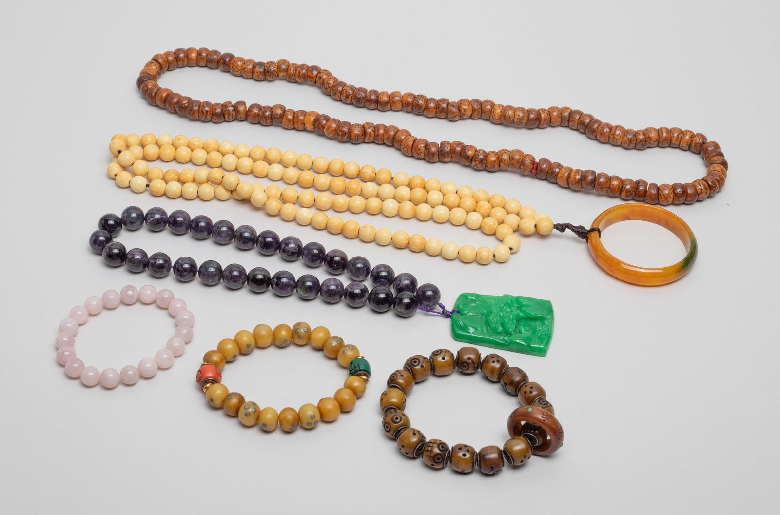 Estate Chinese Beads & Necklaces Collection: Including 2 bone carved bead bracelets, a rose quartz bead bracelet, a bone bead bracelet, a seed bead necklace with a color stone huan, and a string of amethyst bead with a color stone plaque. Approx