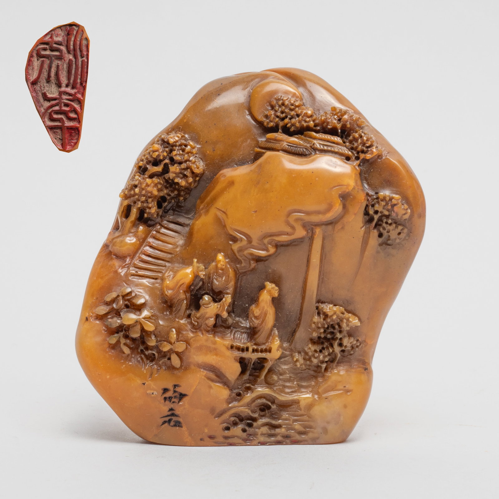 Chinese Shoushan Stone Seal: Of irregular shape, carved in multiple layers of relief with figures standing along riverbank, distant with stairs, pavilions, and trees. Approx. 3.2*2.7*1.5 inch.