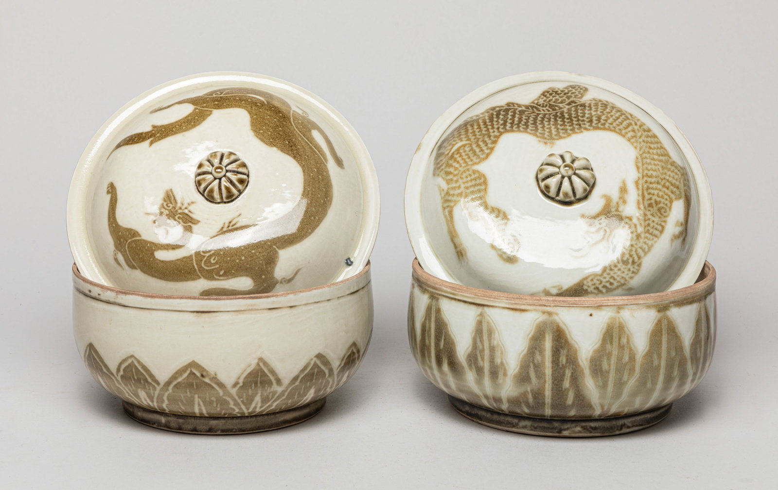 Two Korean Porcelain Covered Bowls: One bowl exterior painted with upright leaves, the lid painted with a dragon, the other bowl exterior with overlapping petals, the lid with an archaistic beast. Approx. 7.3*5.3 inch (each).