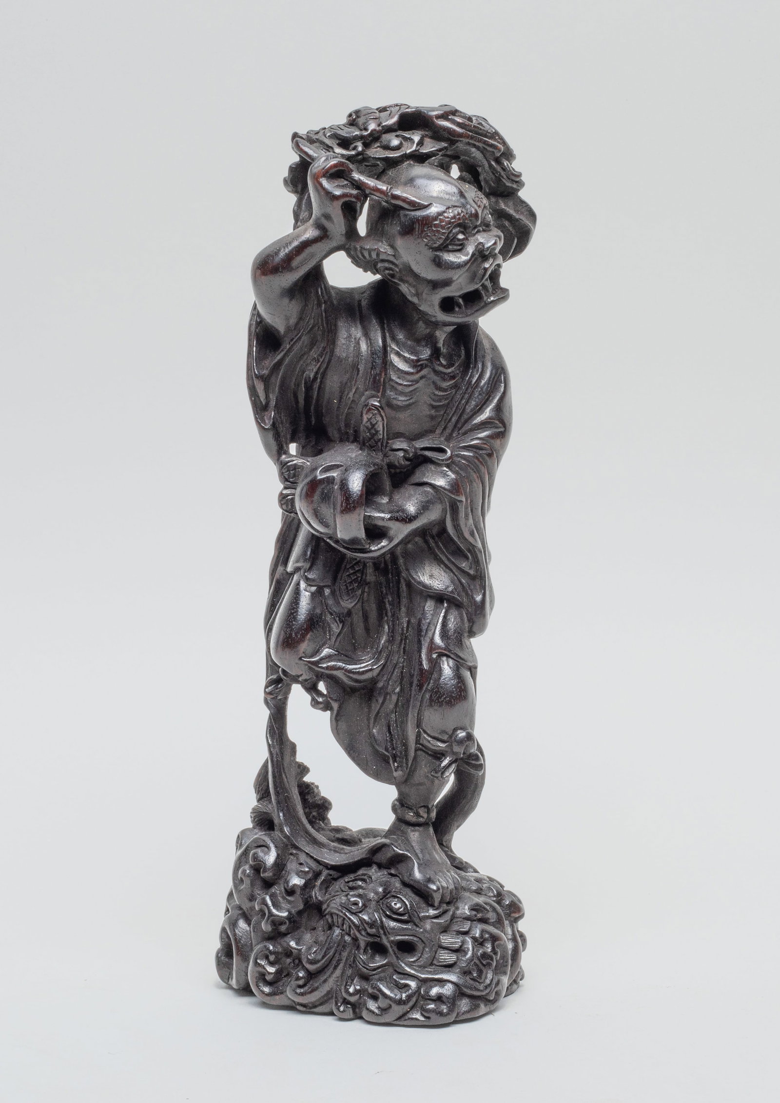 Rare Chinese Zitan Like Sculpture of Kui: Skilfully carved in a dynamic position capturing the movement of the body turned backwards with the right leg raised and the left standing on crashing waves above a turtle, the right hand held high ho