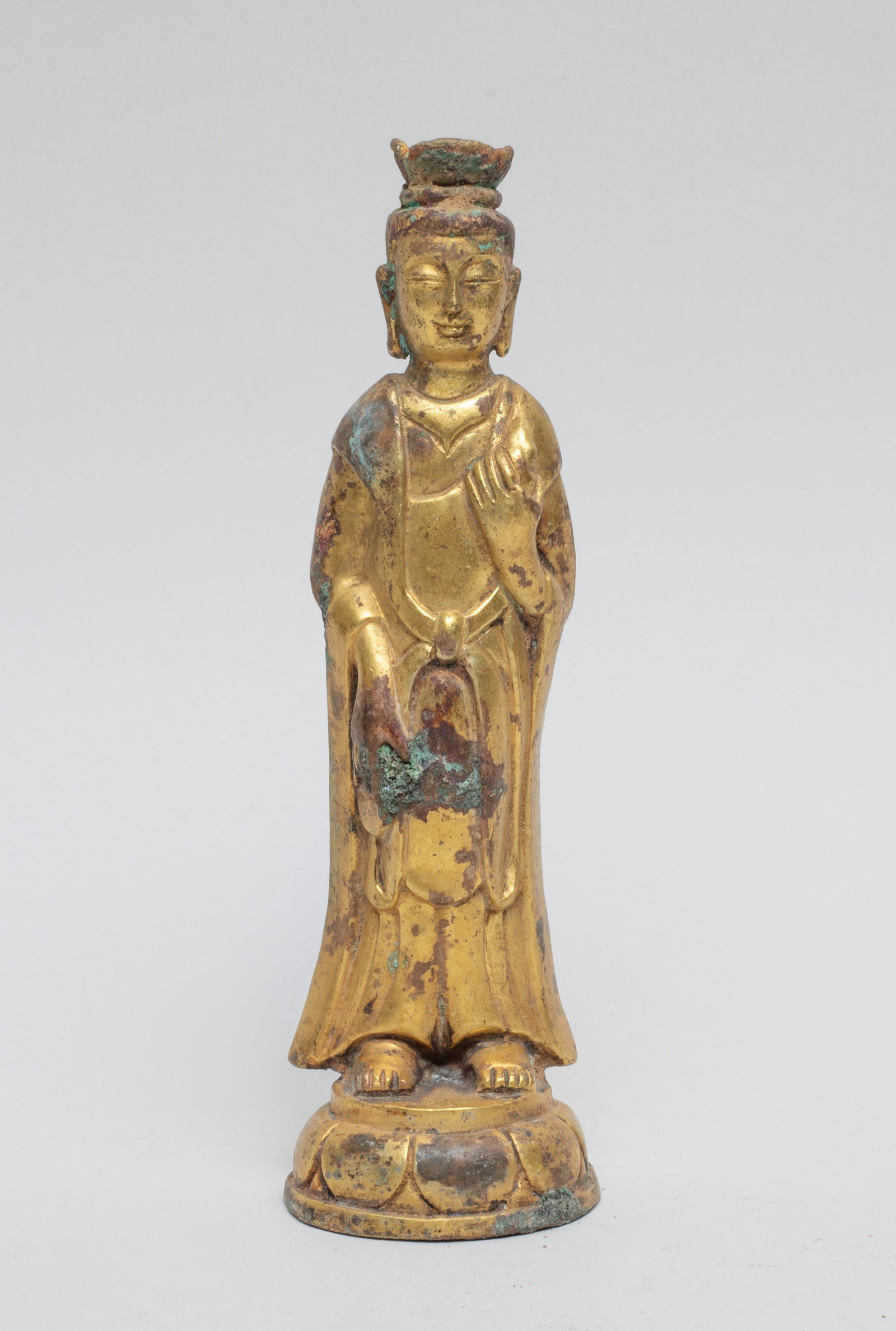 Korean Gilt Bronze Kuanyin: The Kuanyin standing on a lotus base, the right hand in bhumisparshamudra, the left hand raised to the chest, wearing long robes, her face with a peaceful expression. Approx. 6.2-1.8 inch.