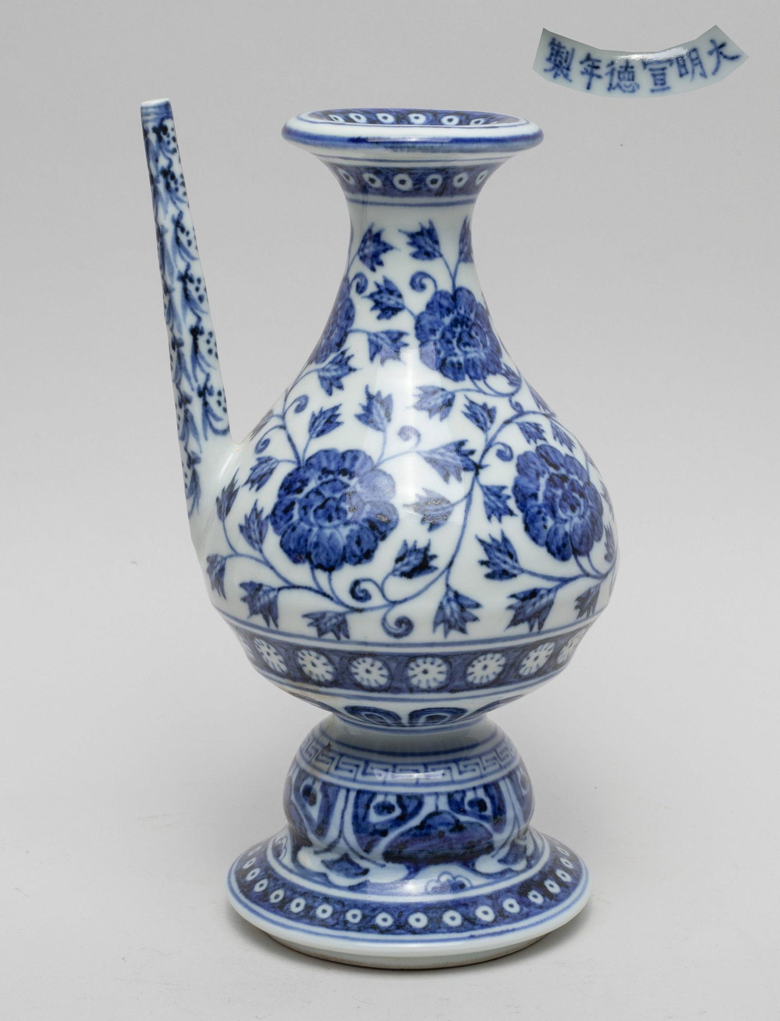 Chinese Export Porcelain Water Pot: Of pear shape rising from a spreading foot to a waisted neck with a flared rim, the exterior painted with undulating leafy lotus scrolls above bands of petals at the foot, the straight spout painted s