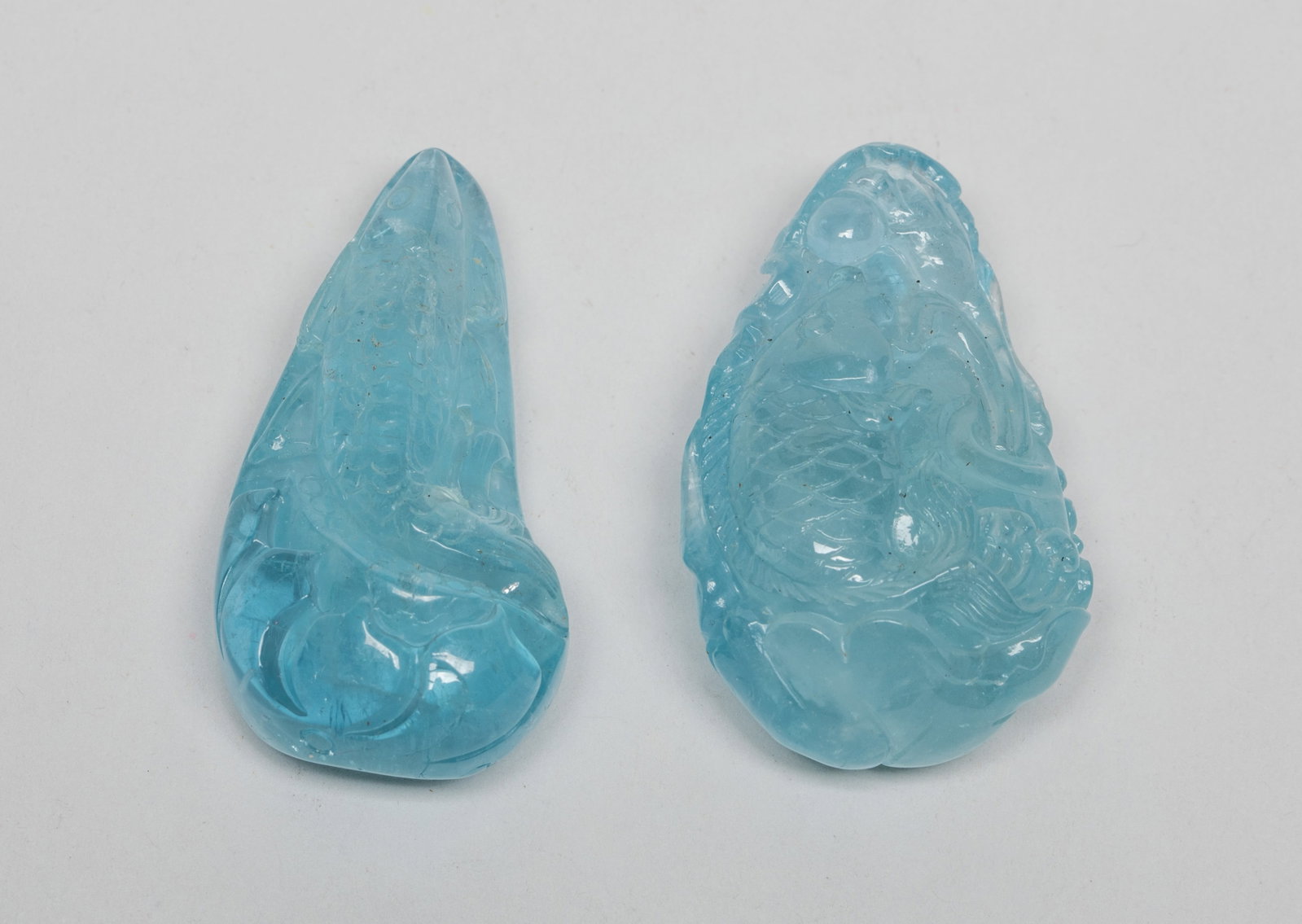 Two Chinese Aquamarine Pendants: Two Chinese aquamarine pendants carved with fish and lotus. Approx. 39 gram (total weight), 1.7*1.05*0.67 inch (larger).
