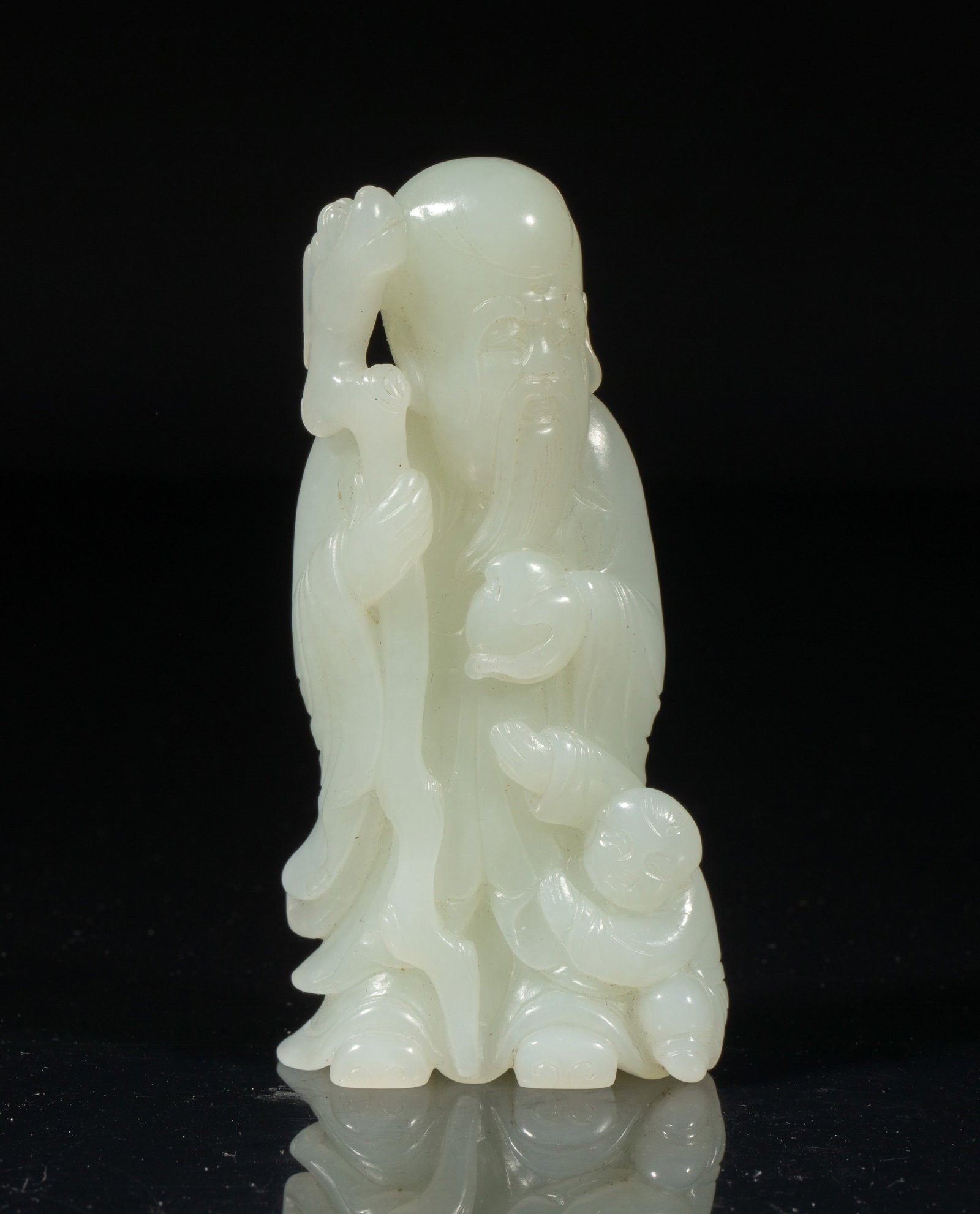 Chinese White Jade Carved Shoulao: Chinese white jade sculpture, the Shoulao wearing a long robe, his left hand holding a peach and right hand grasping a gnarled staff, with a young boy standing to his left, some details finely rendere