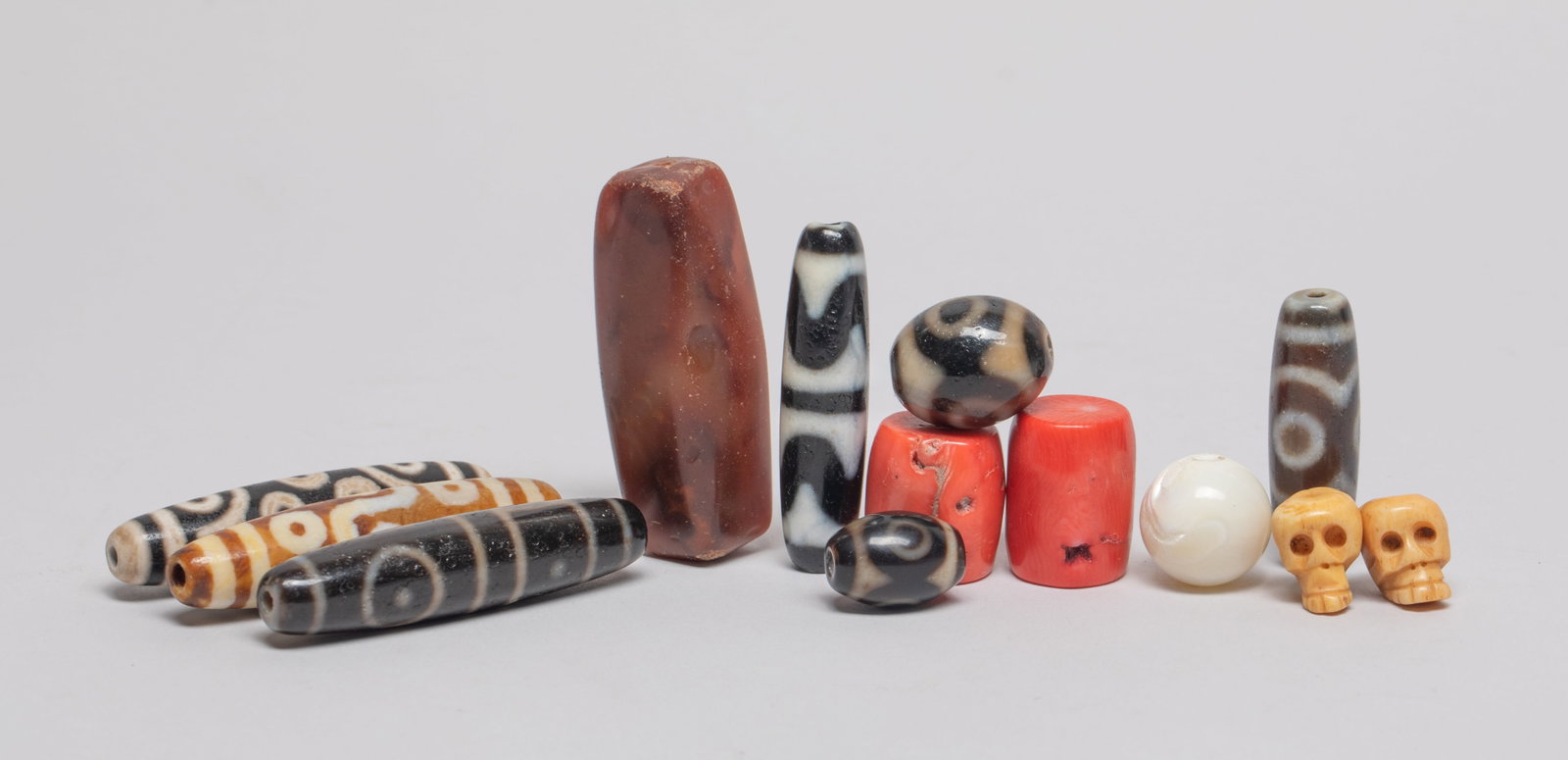Chinese/ Tibetan Beads Collections: Collection of Chinese / Tibetan dzi beads, skull beads, agate, mother-of-pearl and red beads. Approx. 2.3*0.5 inch (longest).