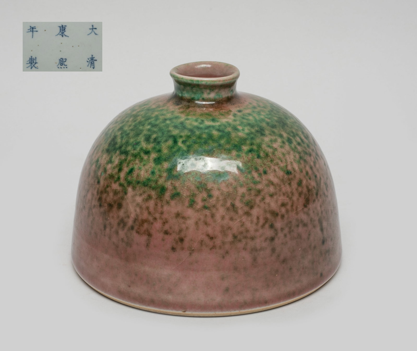 Chinese Flambe Glazed Porcelain Water Pot: Of domed form with a short waisted neck, the exterior covered in crackled dark red glaze suffused with green spots, the bottom marked with six characters in underblue glaze. Approx. 5*3.7 inch.