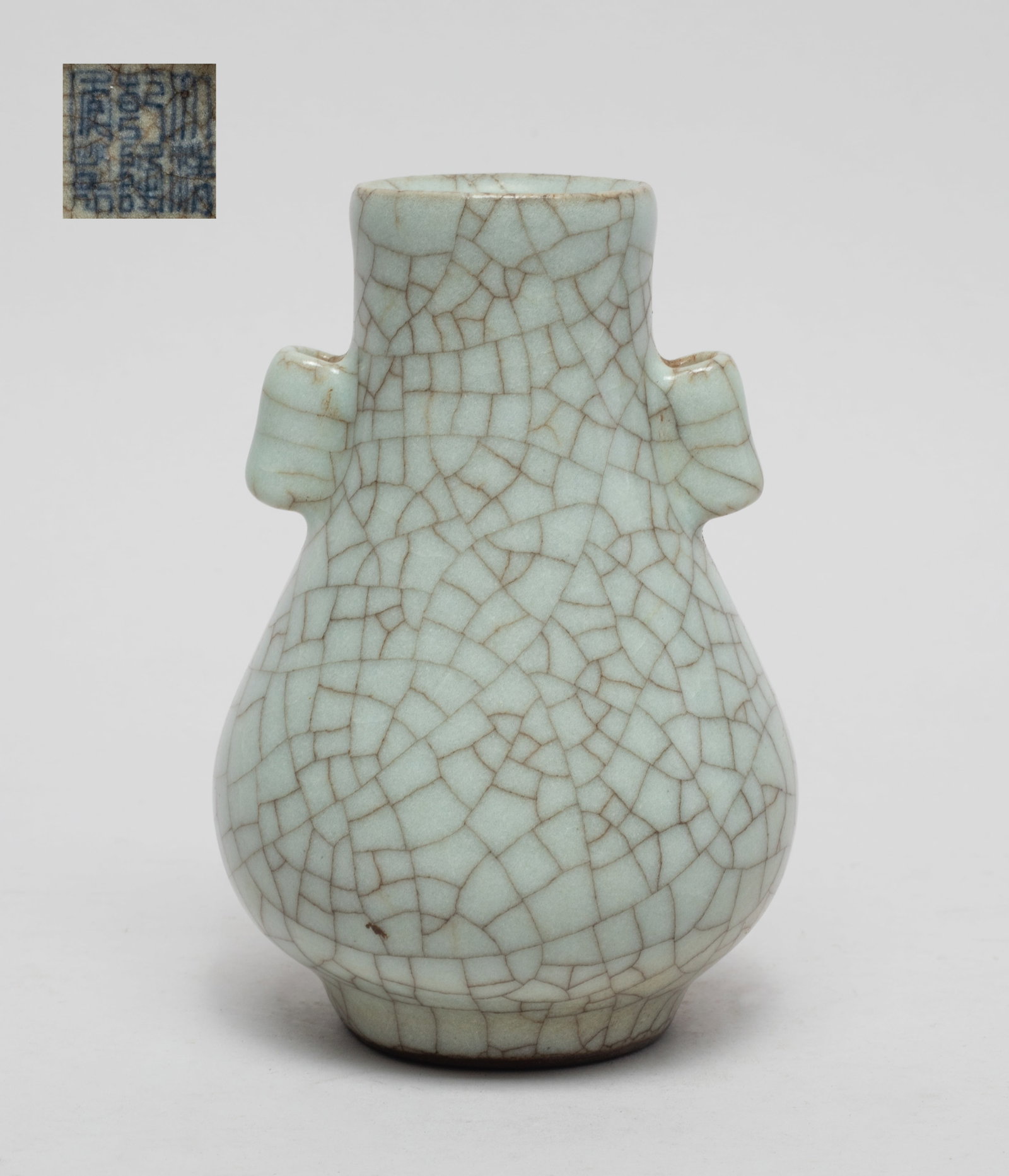 Chinese Ge Ware Porcelain Cabinet Vase: Of pear shape rising from a short tapered foot to a columnar neck with two tubular handles, overall covered in soft gray glaze suffused with a matrix of dark brown crackles, the bottom inscribed with 