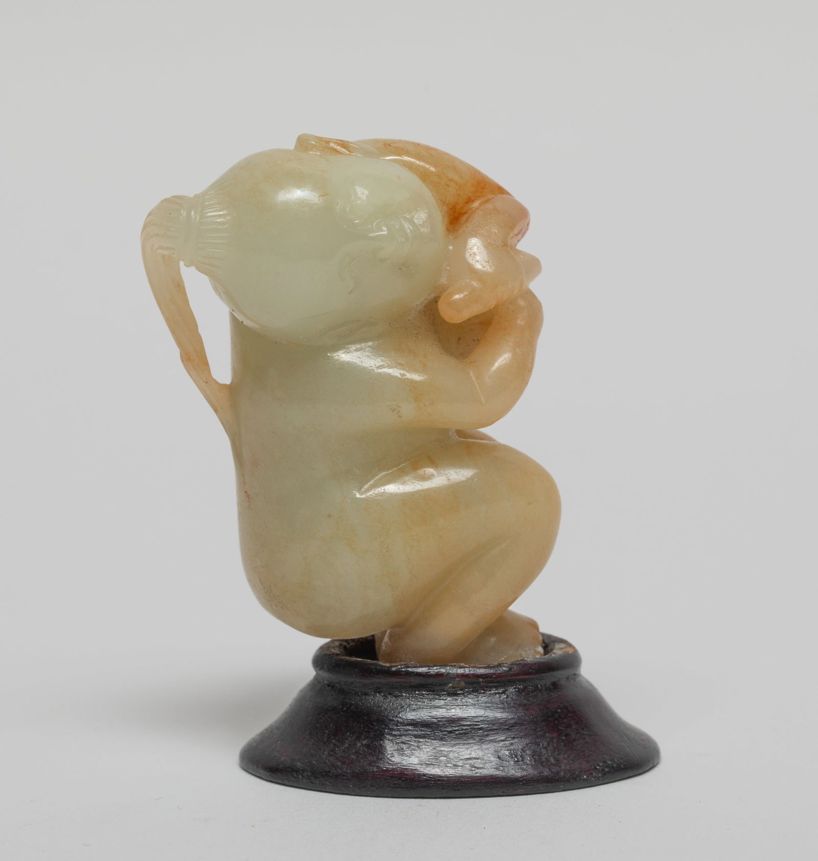 Chinese Jade Figure w/ Stand: Chinese russet jade carved figure in crouching pose, playing a drum, the head tilted to the left, with a stand. Approx. 2.5*1.5*1.2 inch (w/ stand).