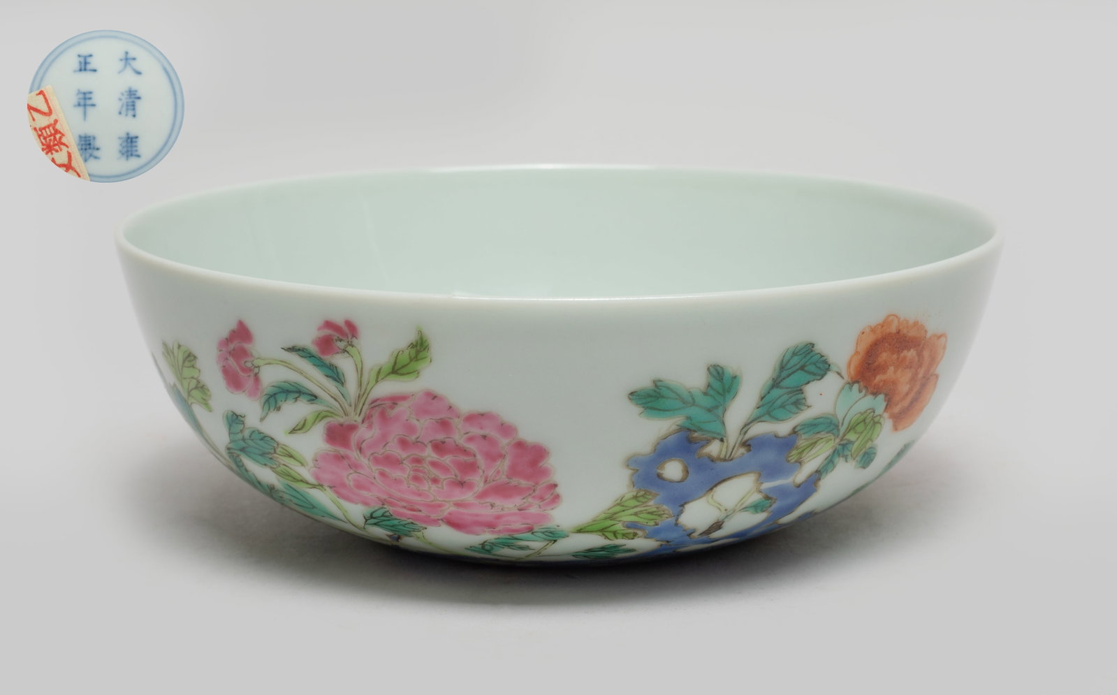 Chinese Famille Rose Porcelain Washer: The exterior enameled with blossoming peony branches issuing from rocks, the bottom marked with six characters enclosed in double circles. Approx. 5.4*1.9 inch.