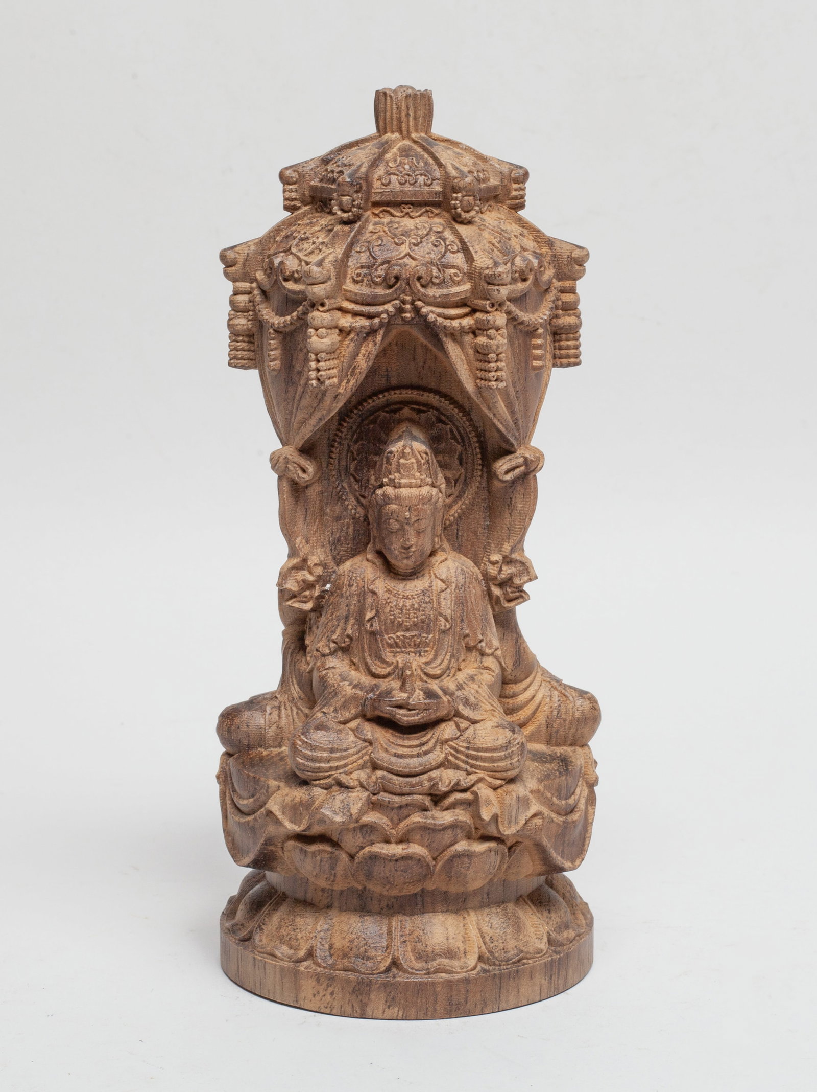 Chinese Export Agarwood Sculpture of Buddha: Carved with three Buddha seated on a lotus throne, each Buddha wearing a loose-fitting robe and holding an implement in hands, surmounted with a canopy detailed with beads and knots. Approx. 7.5*3.2 i