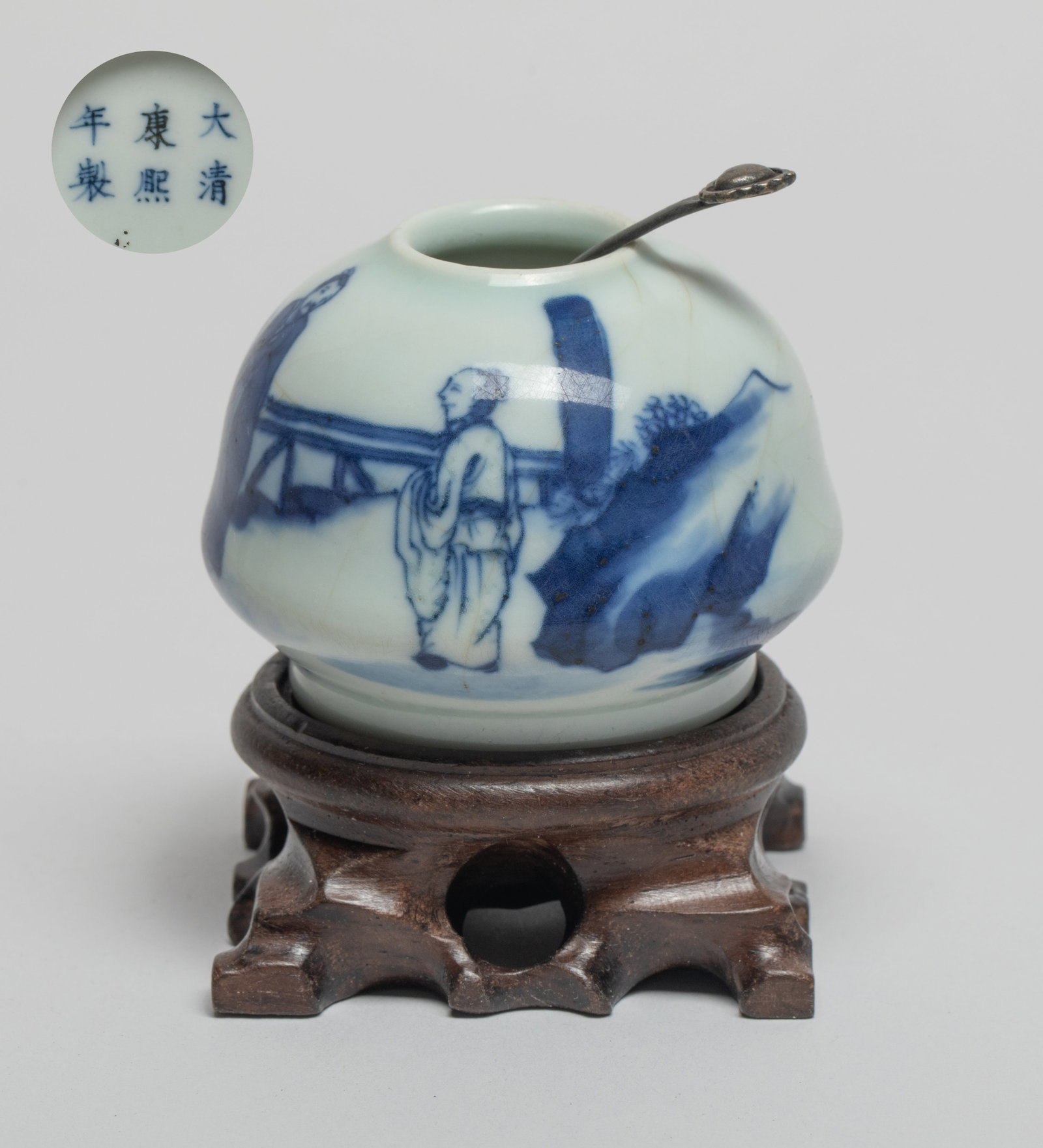 Chinese Porcelain Water Pot w/ Stand: The blue and white porcelain water pot exterior painted with two scholars and a boy, the bottom marked with six characters, with a spoon and a stand. Approx. 2.37*1.75 inch (w/o stand).