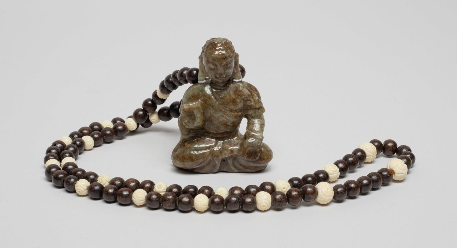 Chinese Export Agarwood, Jade Necklace: Chinese agarwood and bone carved necklace, with a russet jade toggle carved in seated Buddha form. Approx. 26inch L (necklace size). The Estate of The Store Closed Sale, Little Tokyo, Los Angeles.