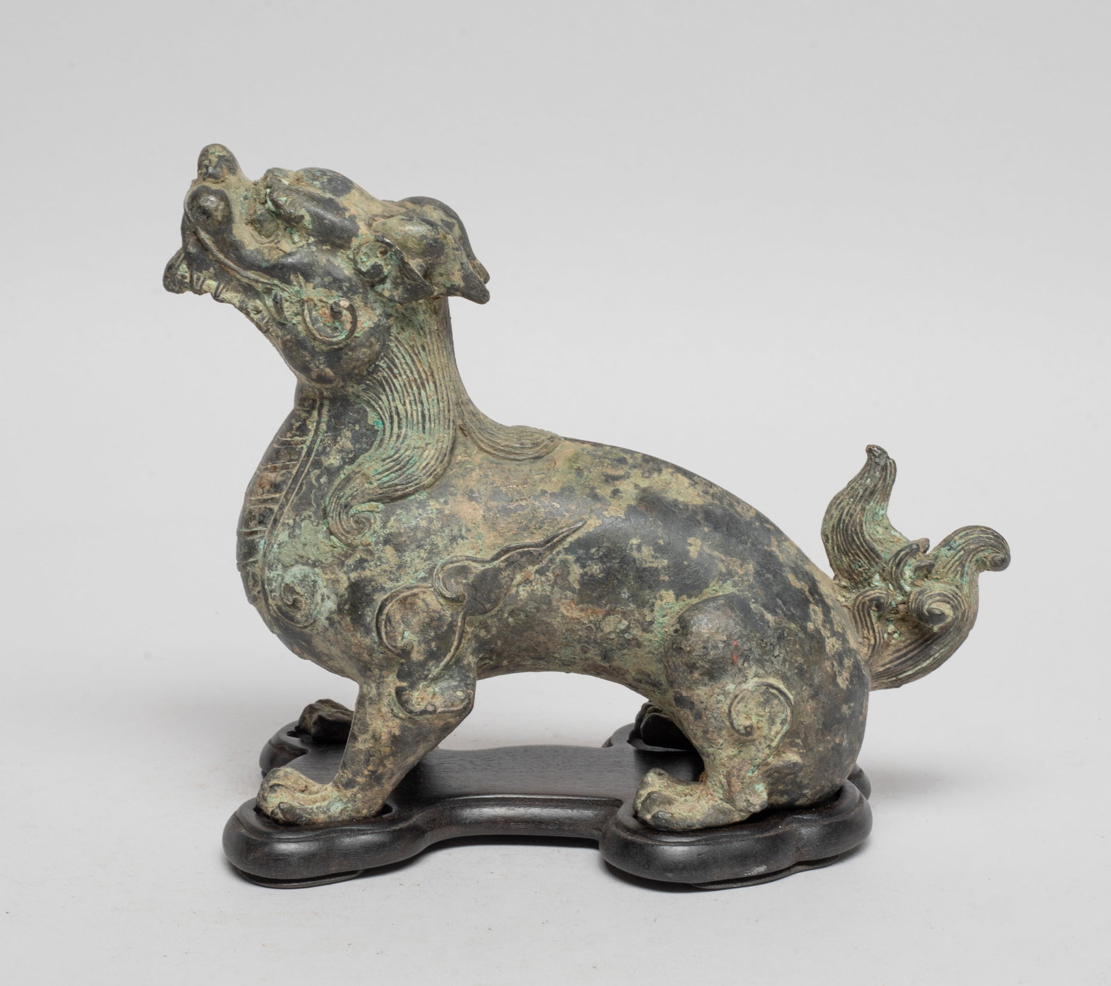 Collectible Chinese Bronze Foo Dog Sculpture: Cast as a cruching foo dog, with bushy hair and tail, the gently open mouth baring its teeth, with a matched stand. Approx. 4.9*6.1*2.4 inch (w/o stand).