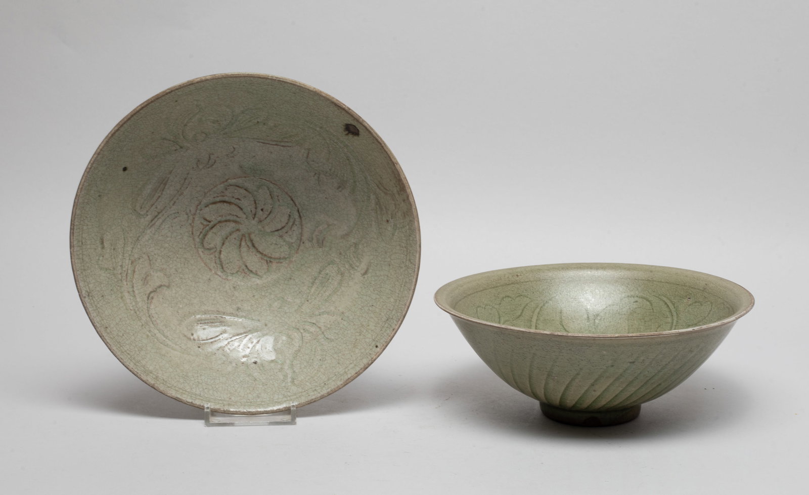 Two Chinese Shipwreck Porcelain Large Bowls: Each bowl interior carved in low relief with stylized flowers, the exterior carved with radiating lines, covered with crackled mottled celadon glaze. Approx. 7.5*2.7 inch (larger). The Estate of the R