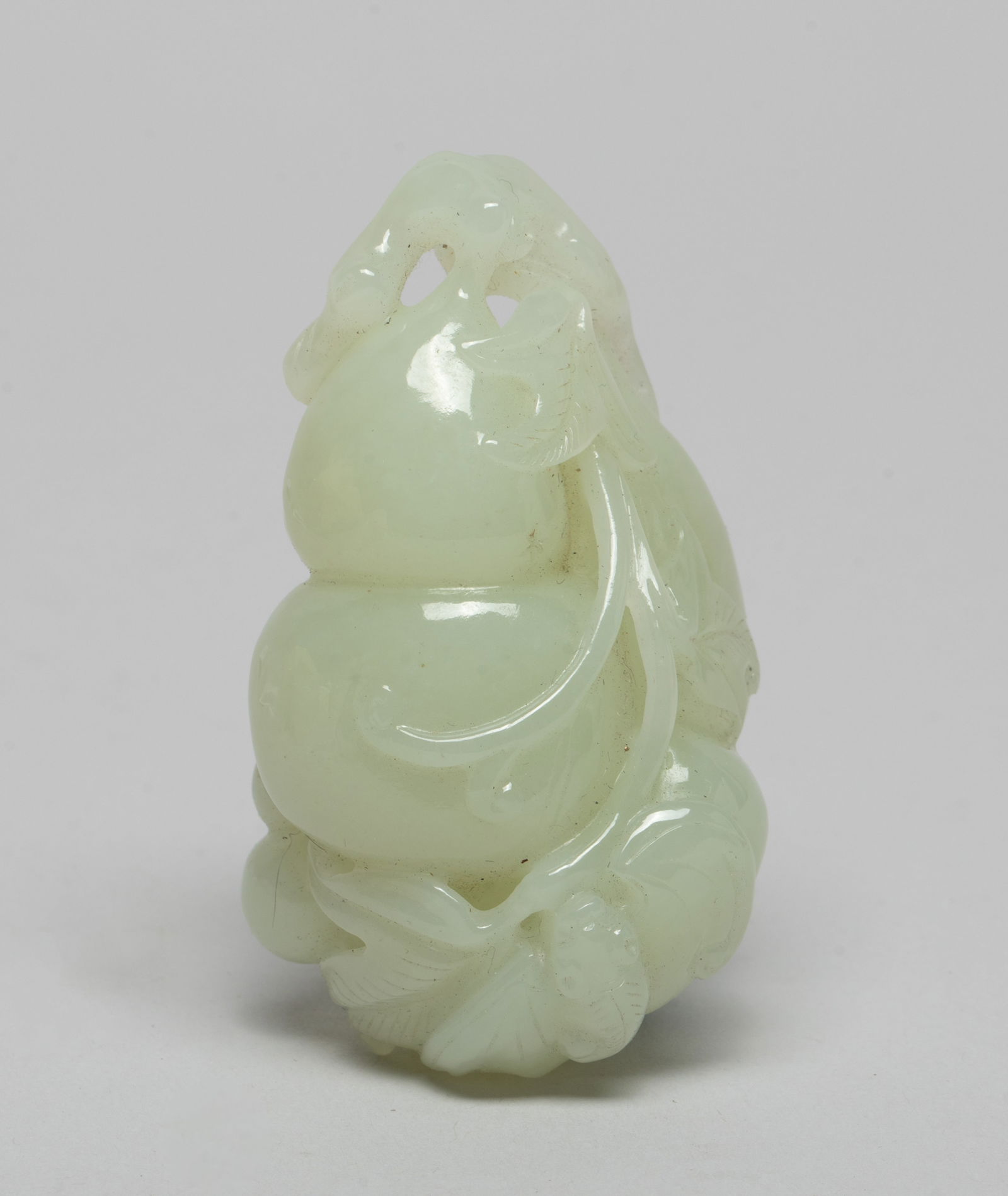 Chinese White Jade Pendant of Gourd: Rendered as a double gourd with further smaller attendant gourds borne on leafy vines with curling tendrils, with a bat perched near the bottom of the main fruit. Approx. 2.7*1.6*1.3 inch.
