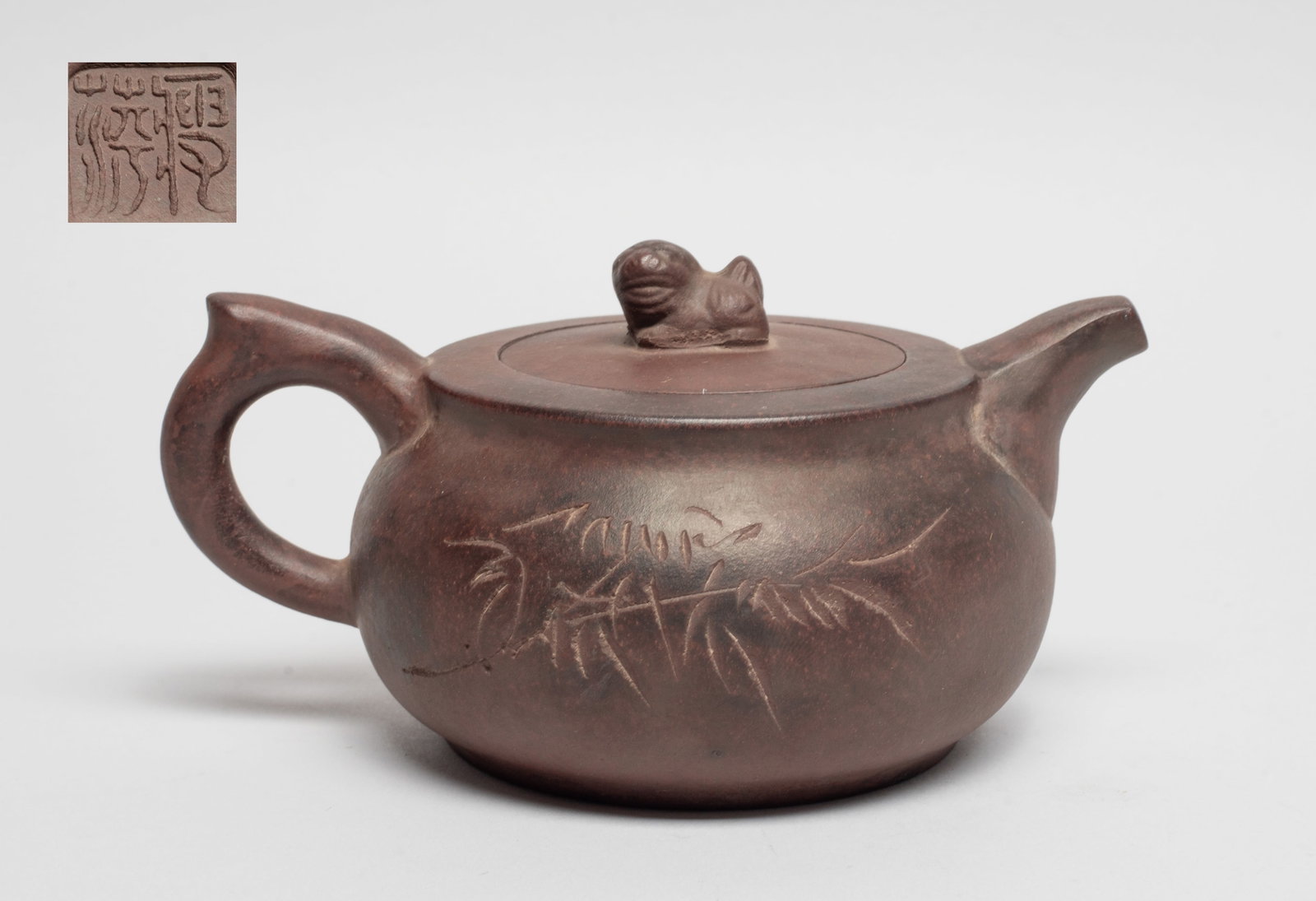 Chinese Yixing Zisha Tea Pot: The tea pot exterior incised with bamboo and inscribed with related passages, the bottom carved with mark. Approx. 6.2*4.5*3.3 inch.